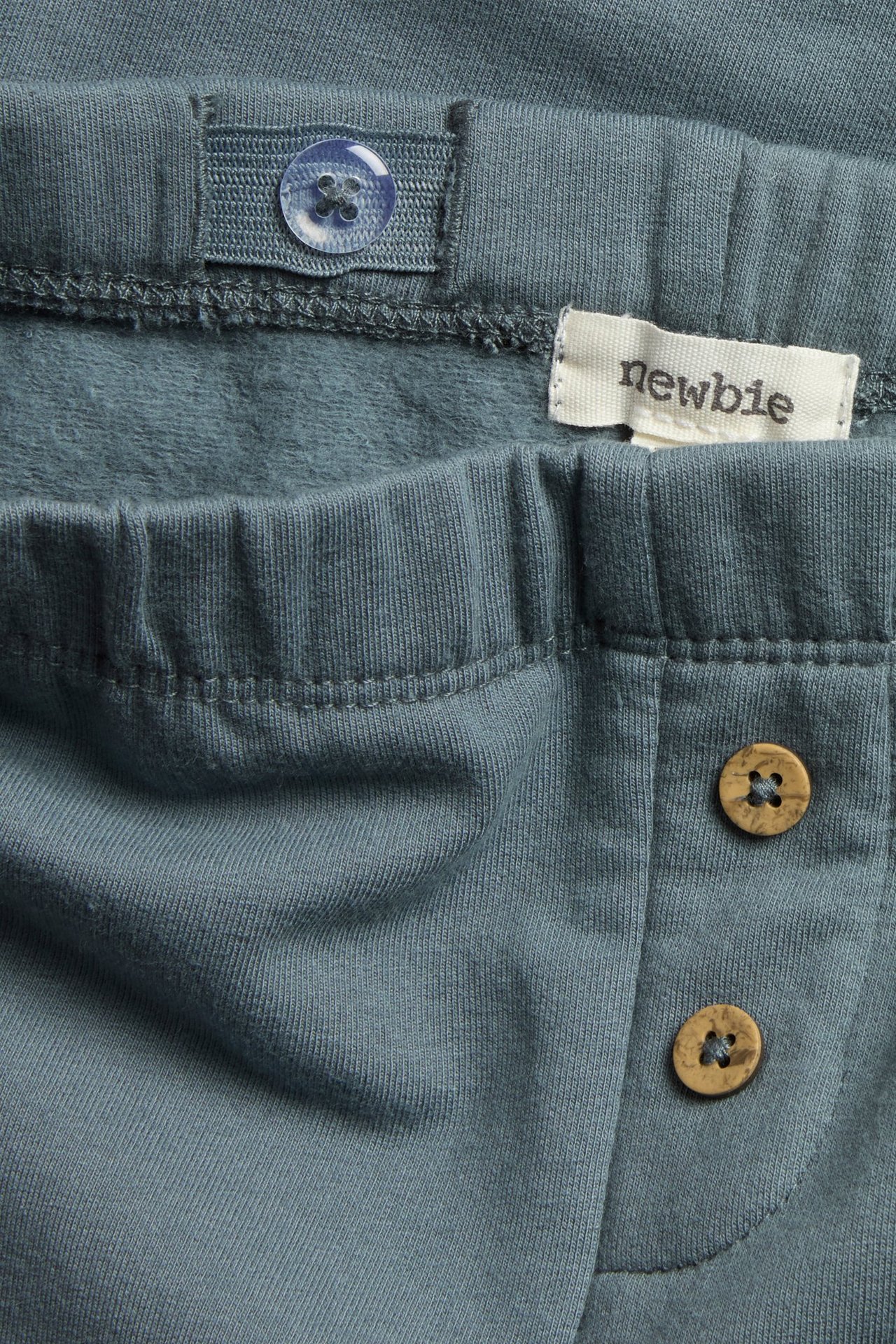 Blaue Fleecleggings für Kinder mit Knie-Applikation, verstellbare Taille und vordere Knöpfe.