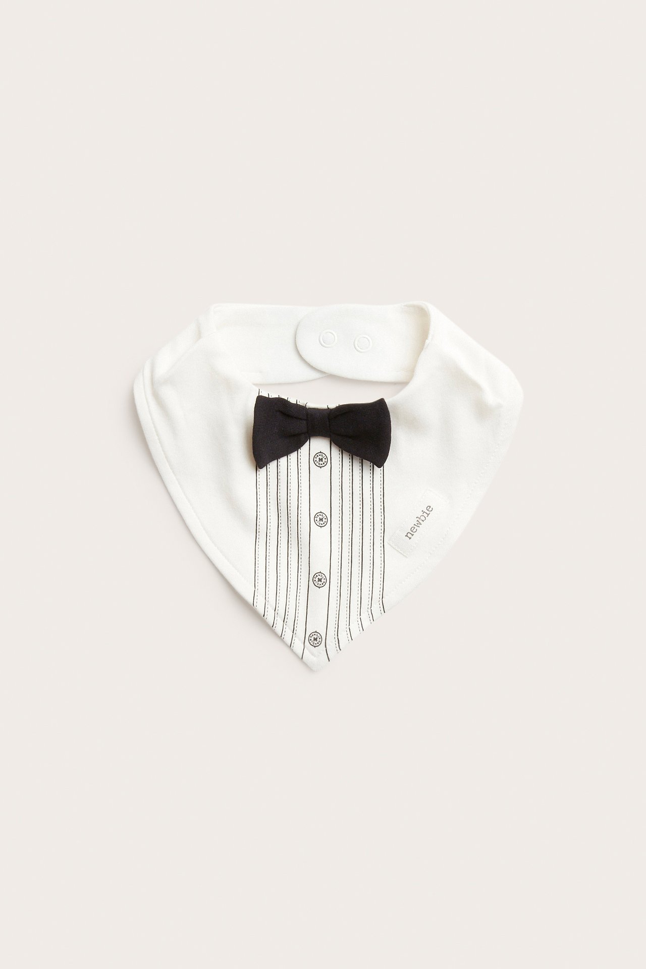 Front view of a white baby bib with tuxedo shirt design, black bow tie, and buttons.