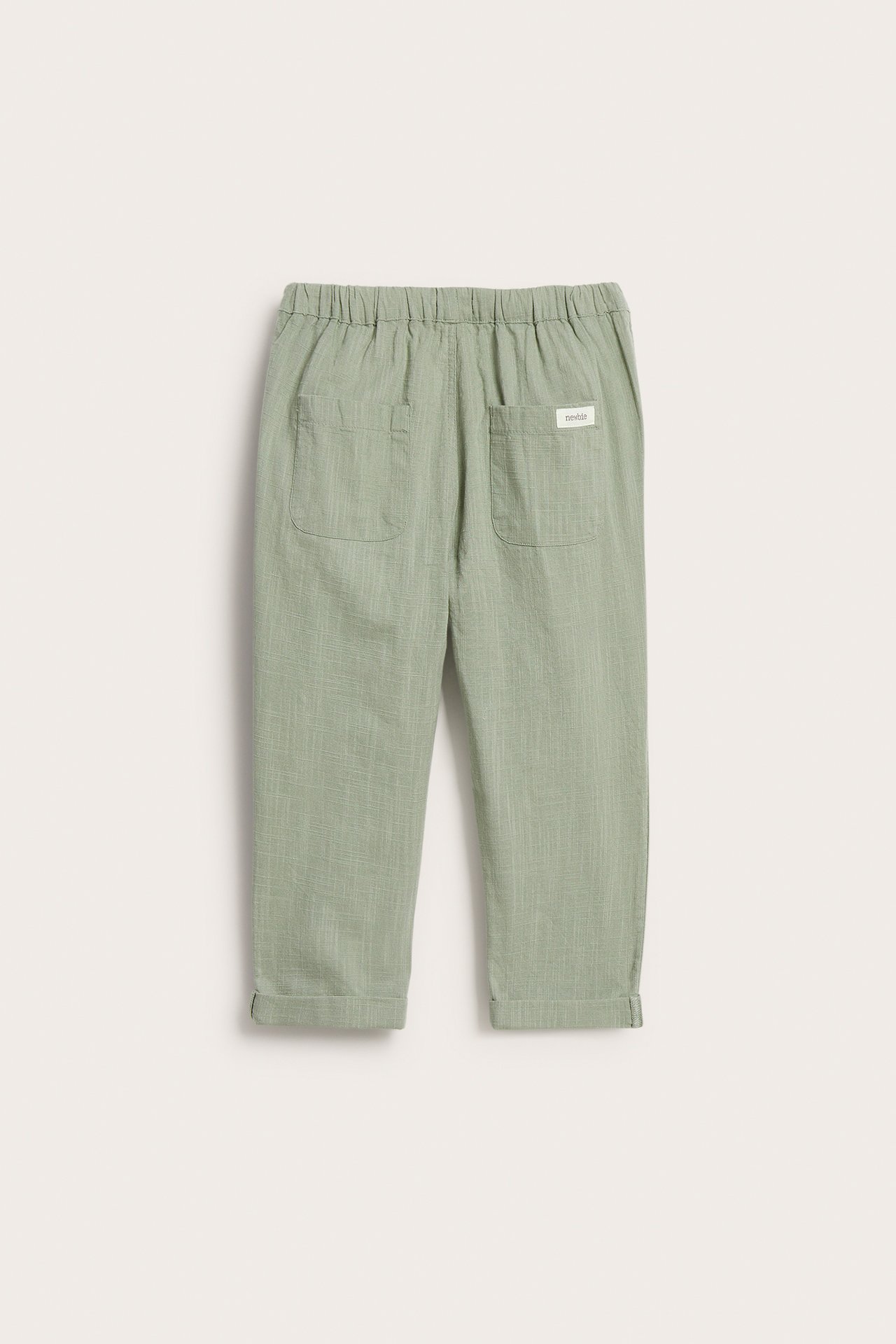 Back view of dark green textured cotton trousers with an elasticated waist and two back patch pockets.