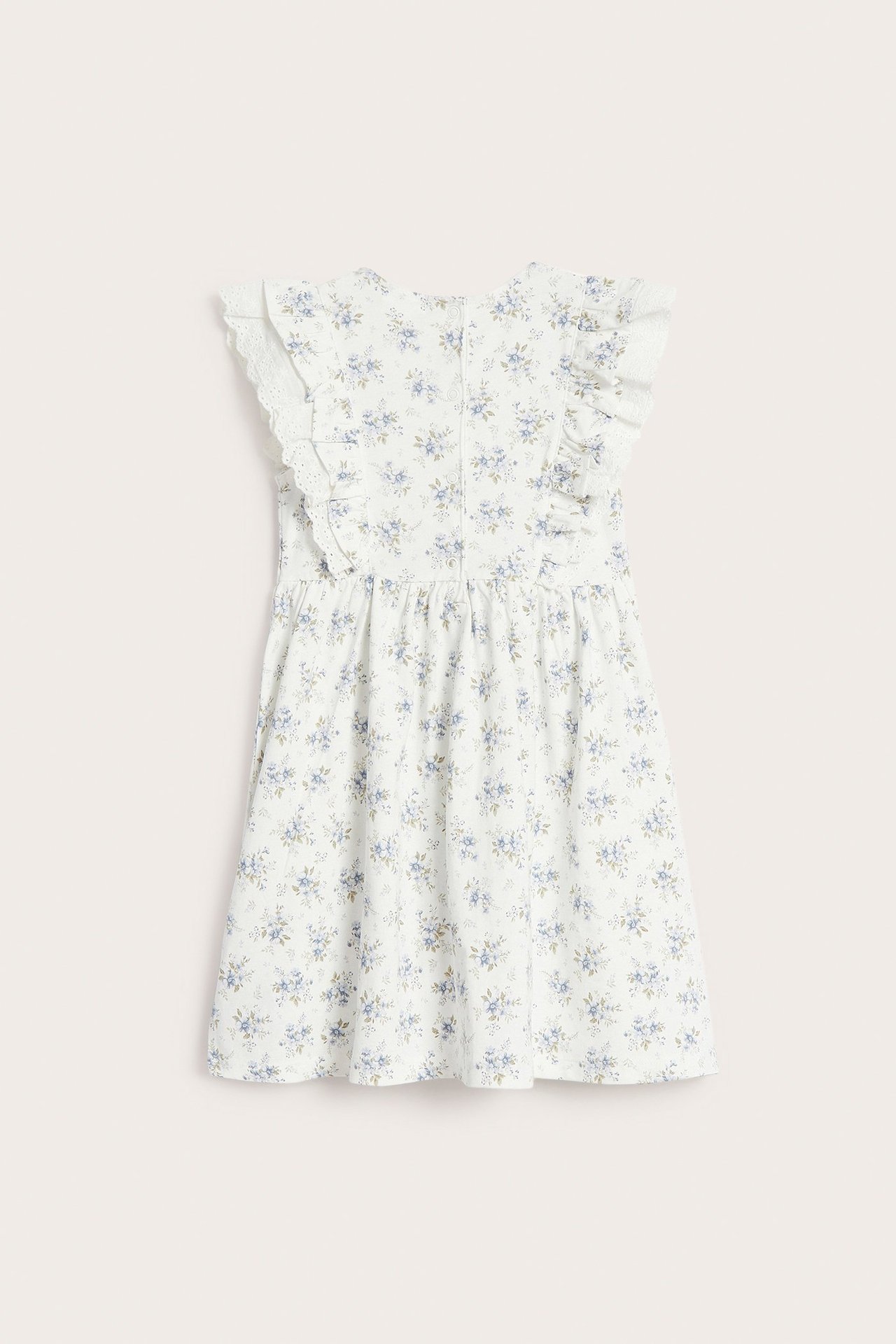 Rückenansicht: Off-weißes Kinder-Baumwolljerseykleid mit kleinem blauen Blumenmuster, Rüschen, Spitze und Druckknöpfen.