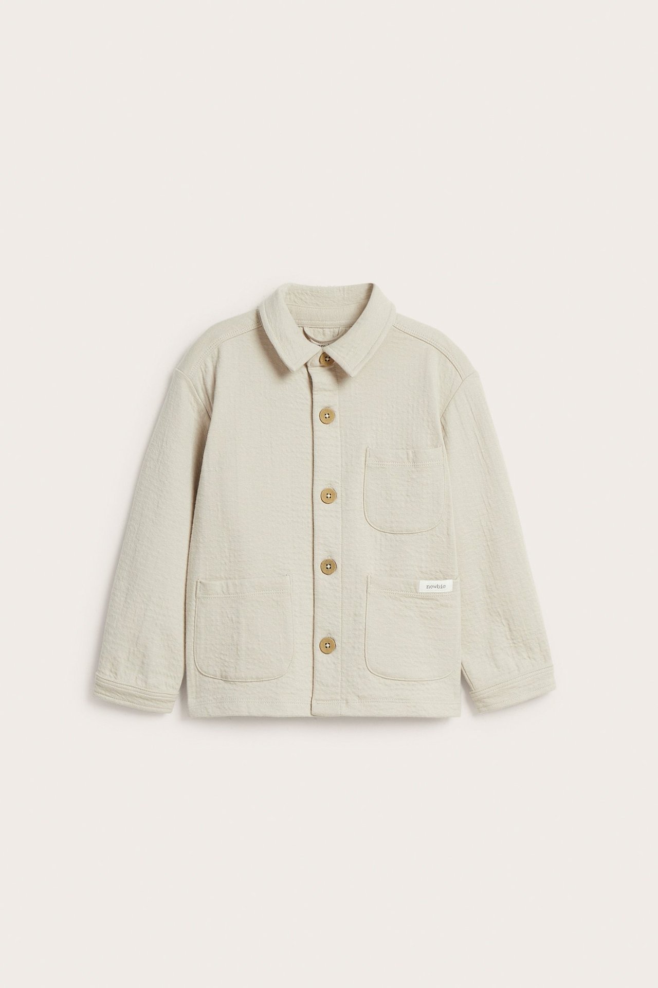 Vorderansicht: Kinder-Overshirt in Beige aus strukturiertem Jersey mit Kragen, fünf Knöpfen, drei Taschen.
