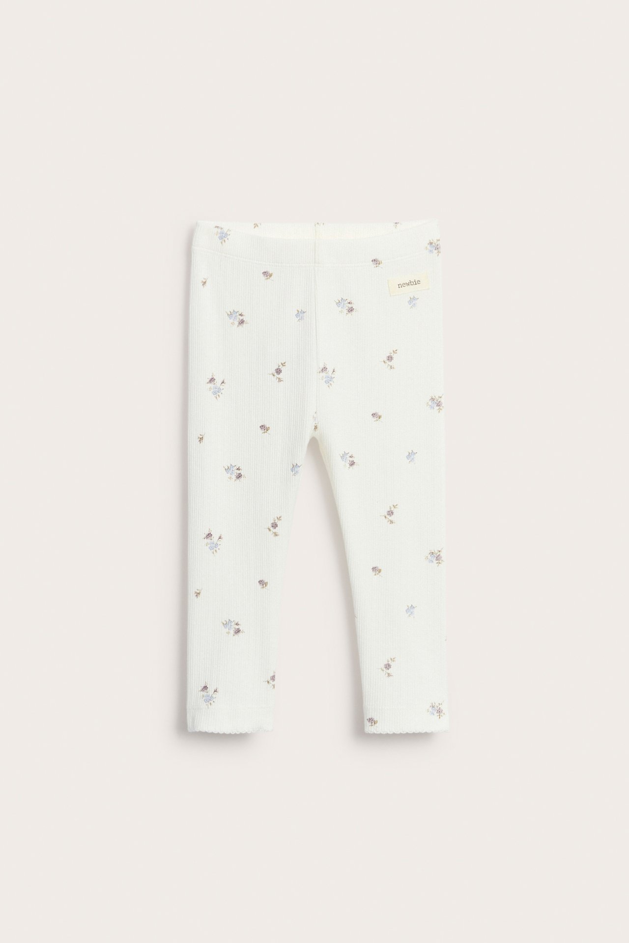 Front view of offwhite ribbed leggings with a delicate floral print and picot edges.
