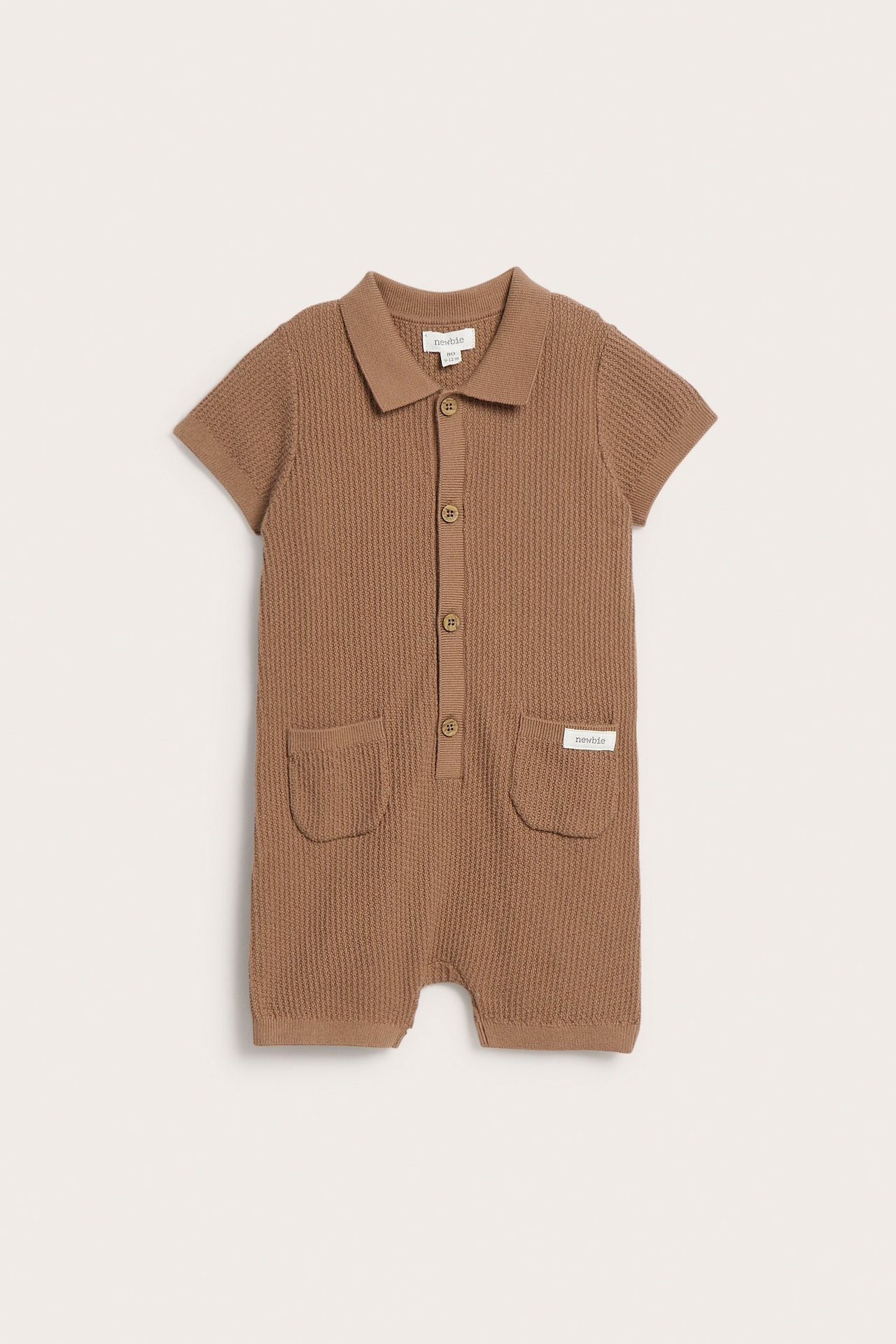 Front view of a brown fine-knit cotton baby romper with short sleeves, collar, front buttons, and pockets.