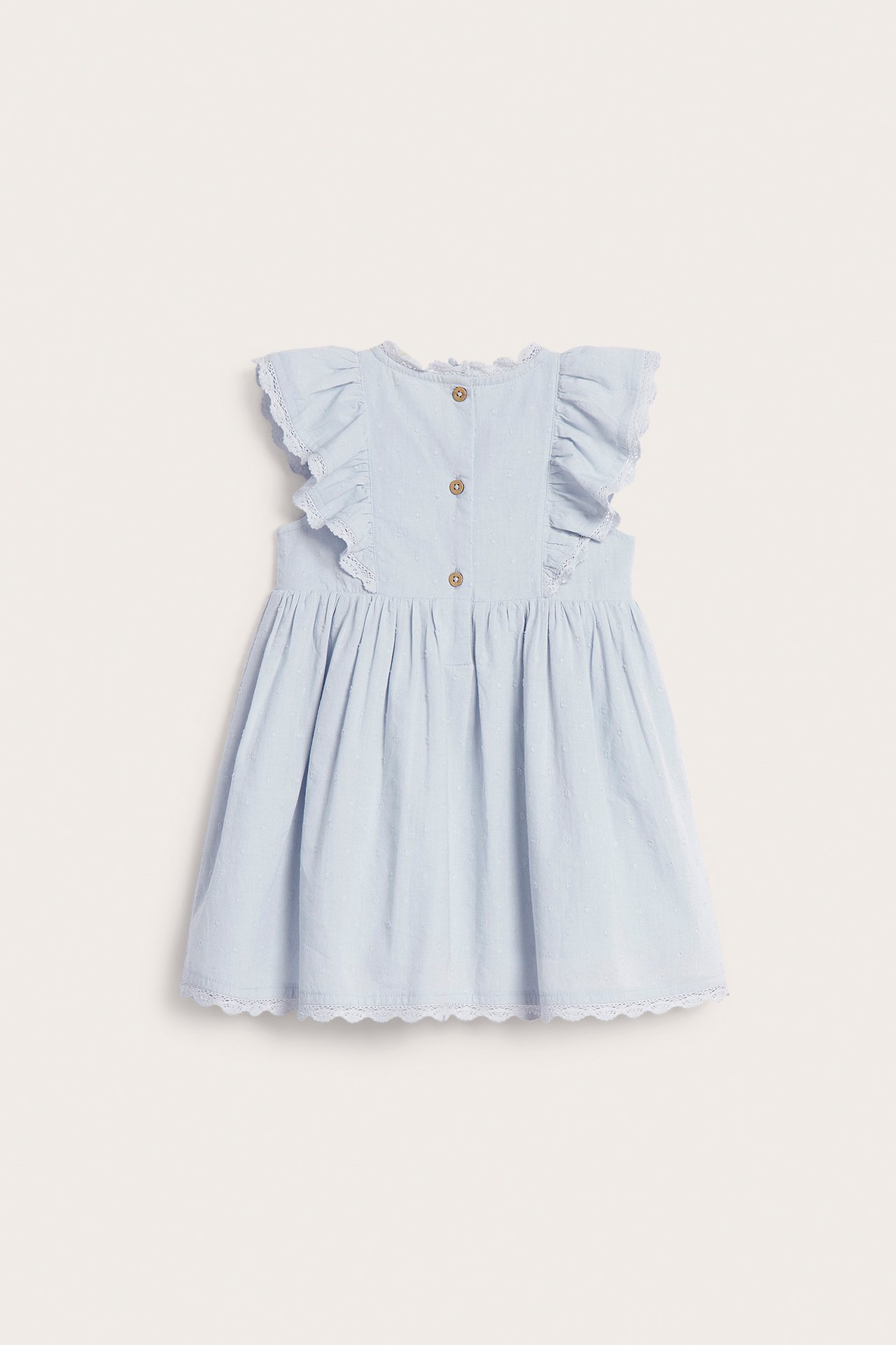 Back view of a light blue baby dress with ruffles, lace trim, and three back buttons.