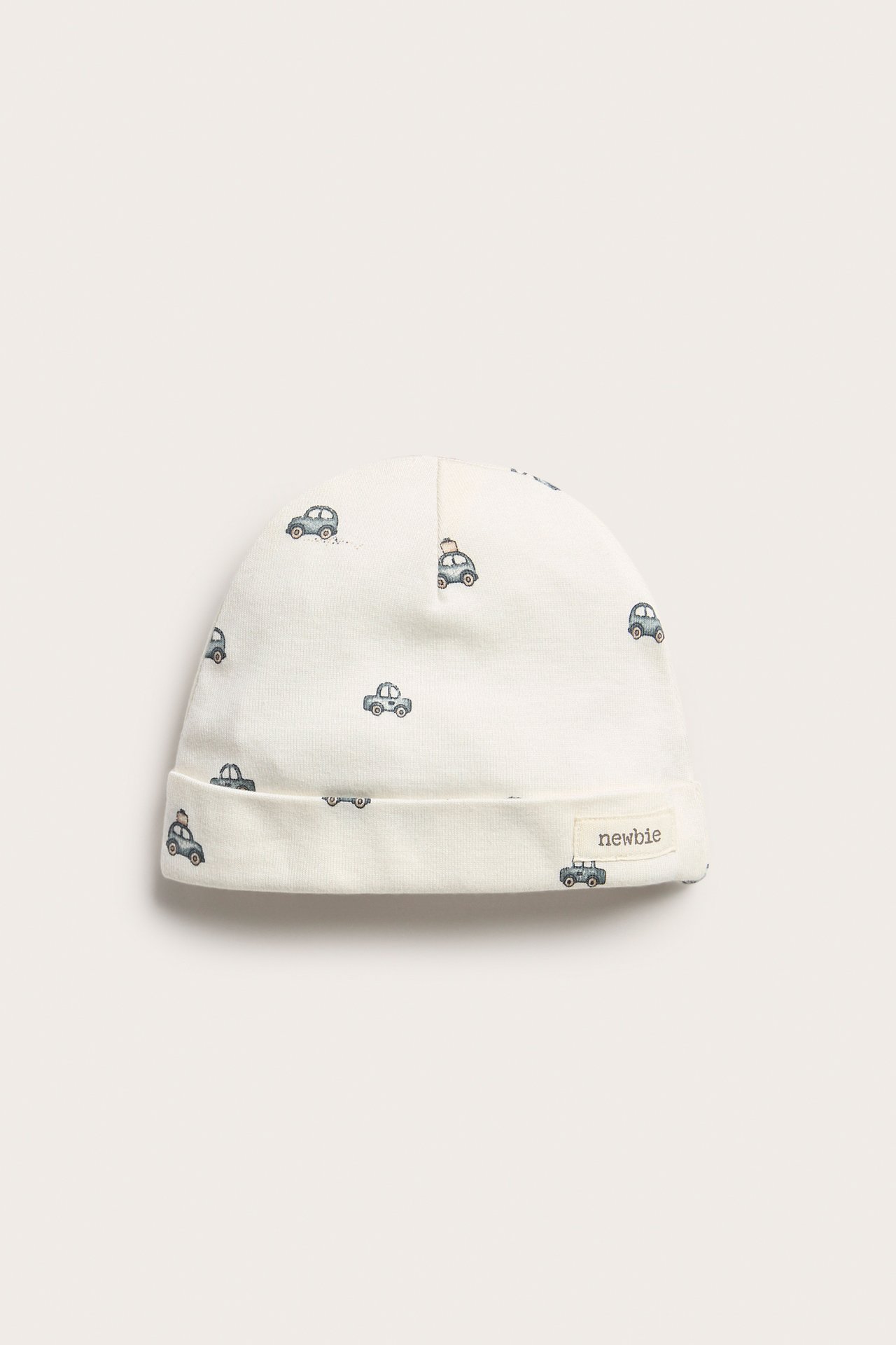 Offwhite cotton hat with small car pattern, front view, for baby.