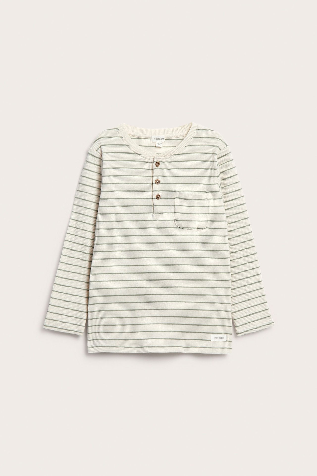 Front view: Kid's off-white waffle knit long-sleeved top with light green stripes, 3 buttons, chest pocket.