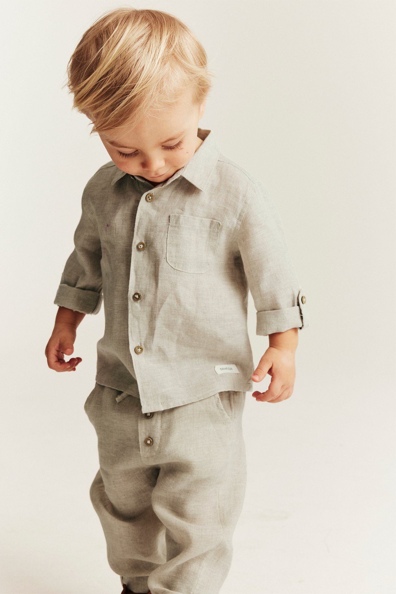 Front view: Baby wears a light beige linen shirt with collar, rolled sleeves, and matching trousers.