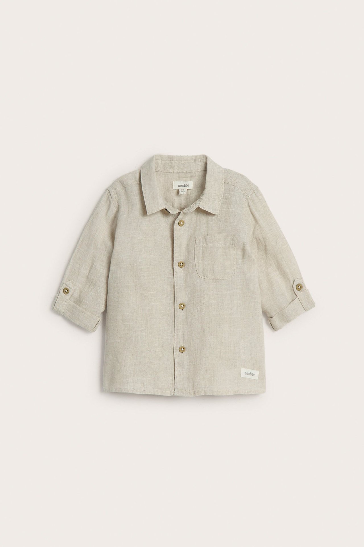 Front view of a kid's light beige linen shirt with collar, button-down front, rolled sleeves, and chest pocket.
