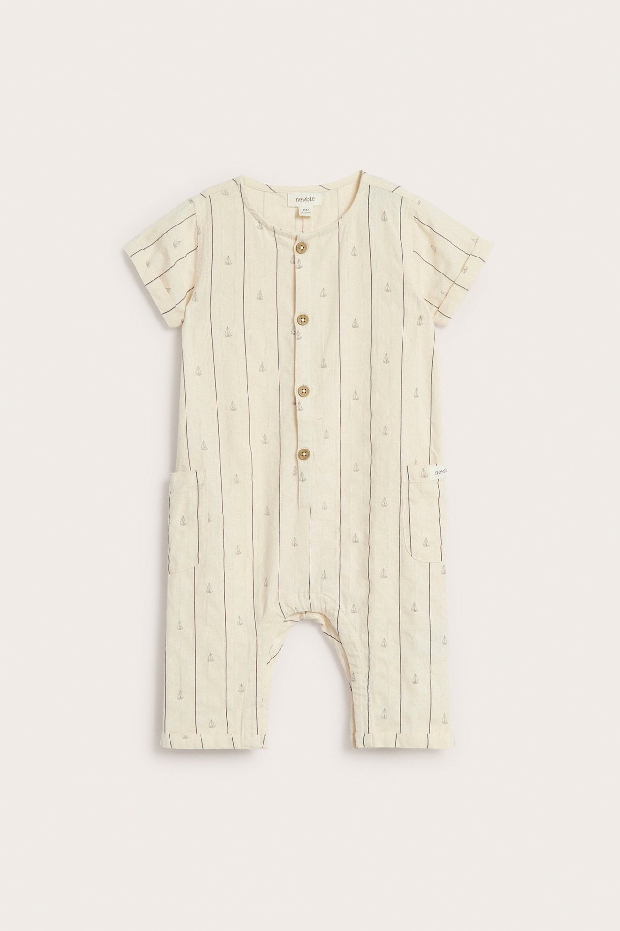 Front view: off-white cotton baby jumpsuit with stripes, sailboats, front buttons, side pockets.