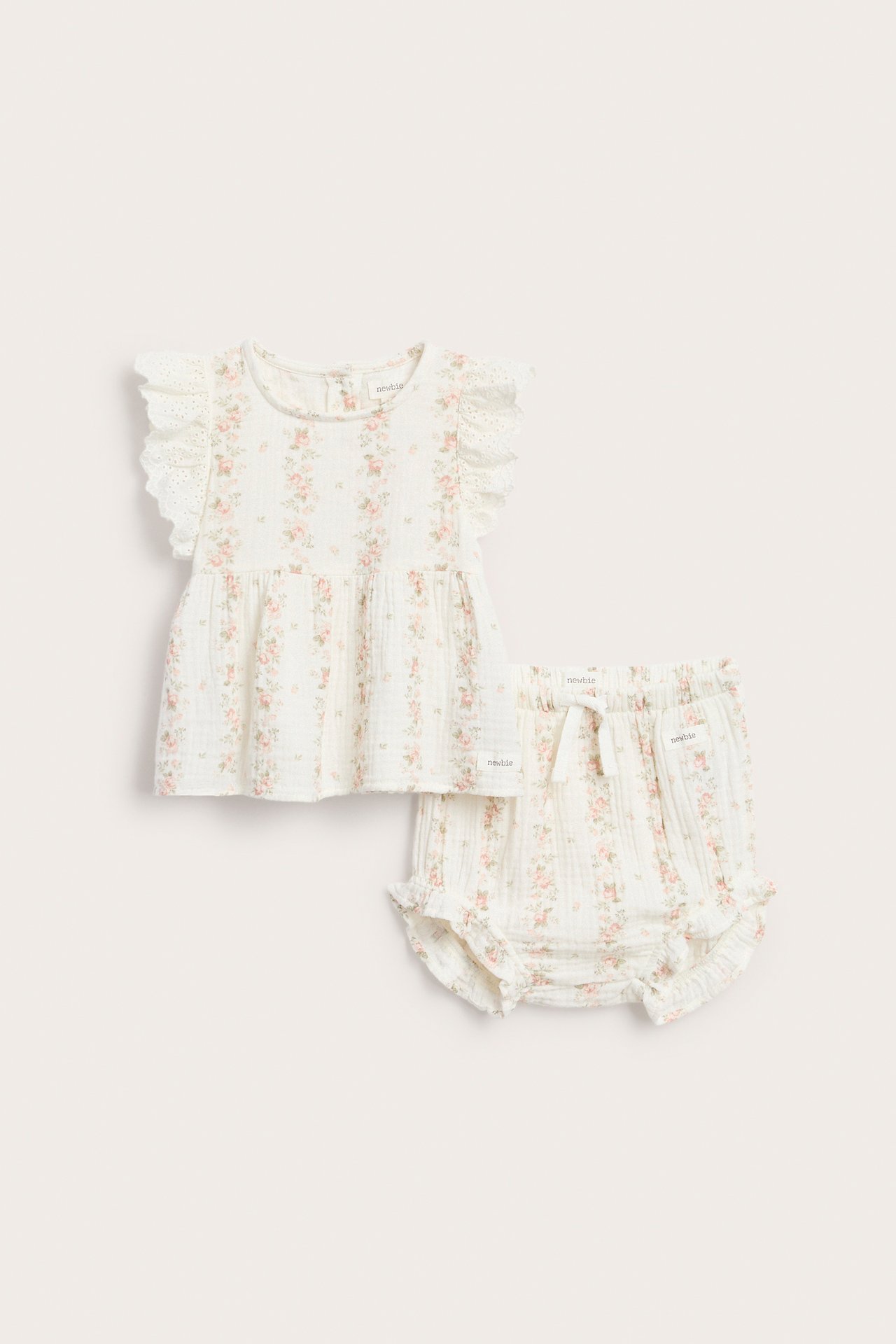 Vorderansicht: Off-weißes Musselin Baby Peplum-Top mit Blumenprint, Rüschenärmeln und passenden Shorts.