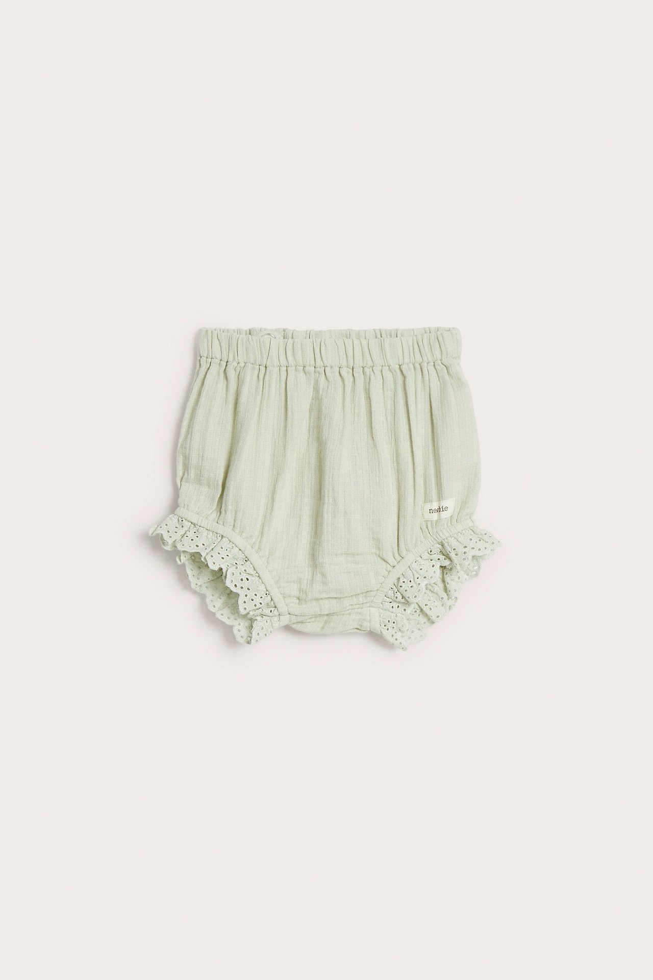 Vorderansicht von hellgrünen gewebten Baby-Shorts aus Baumwolle mit Gummizug und Spitzenrüschen.