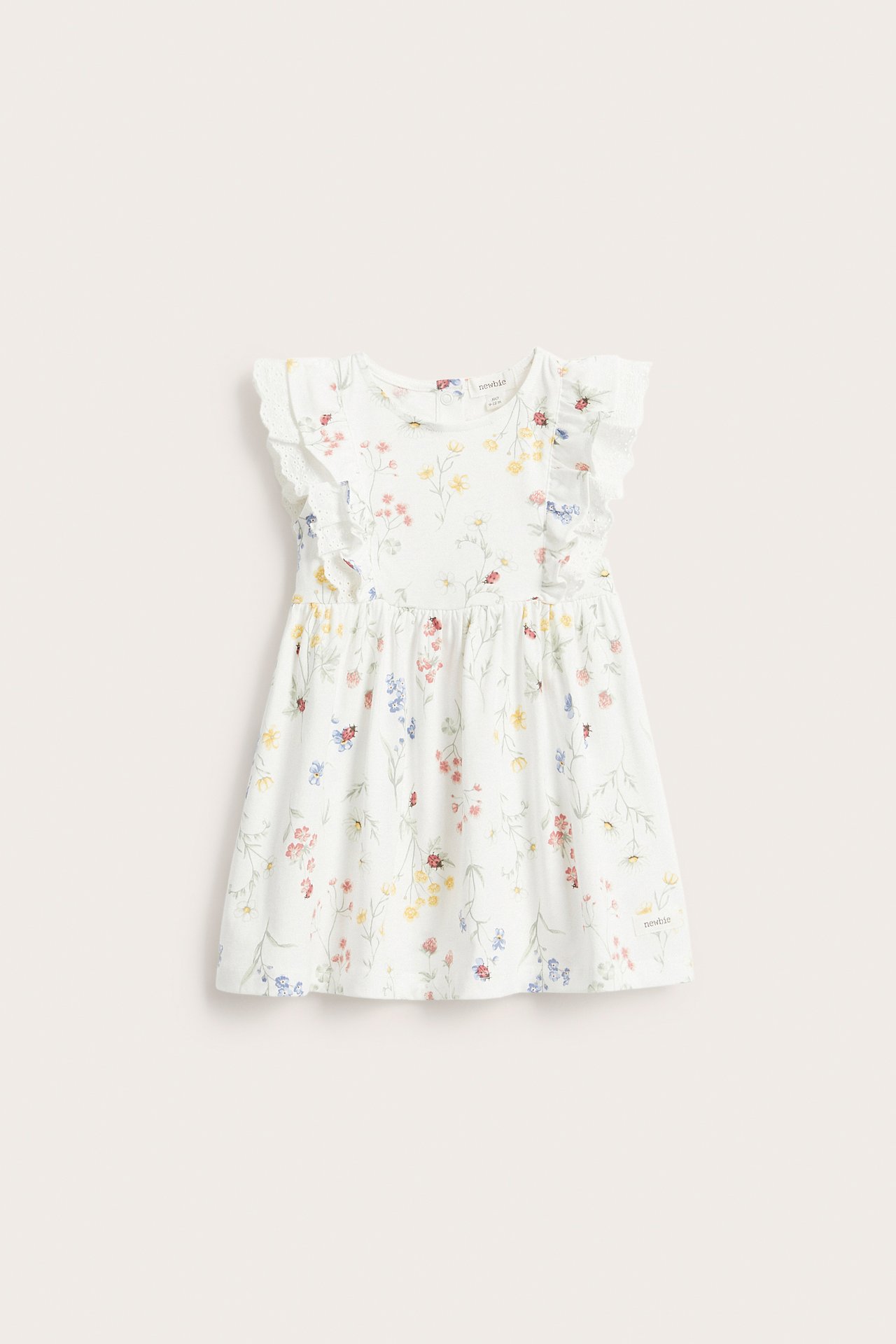 Vorderansicht eines off-white Kinder-Jerseykleides mit Rüschenärmeln, Spitzendetetails und buntem Blumenmuster.