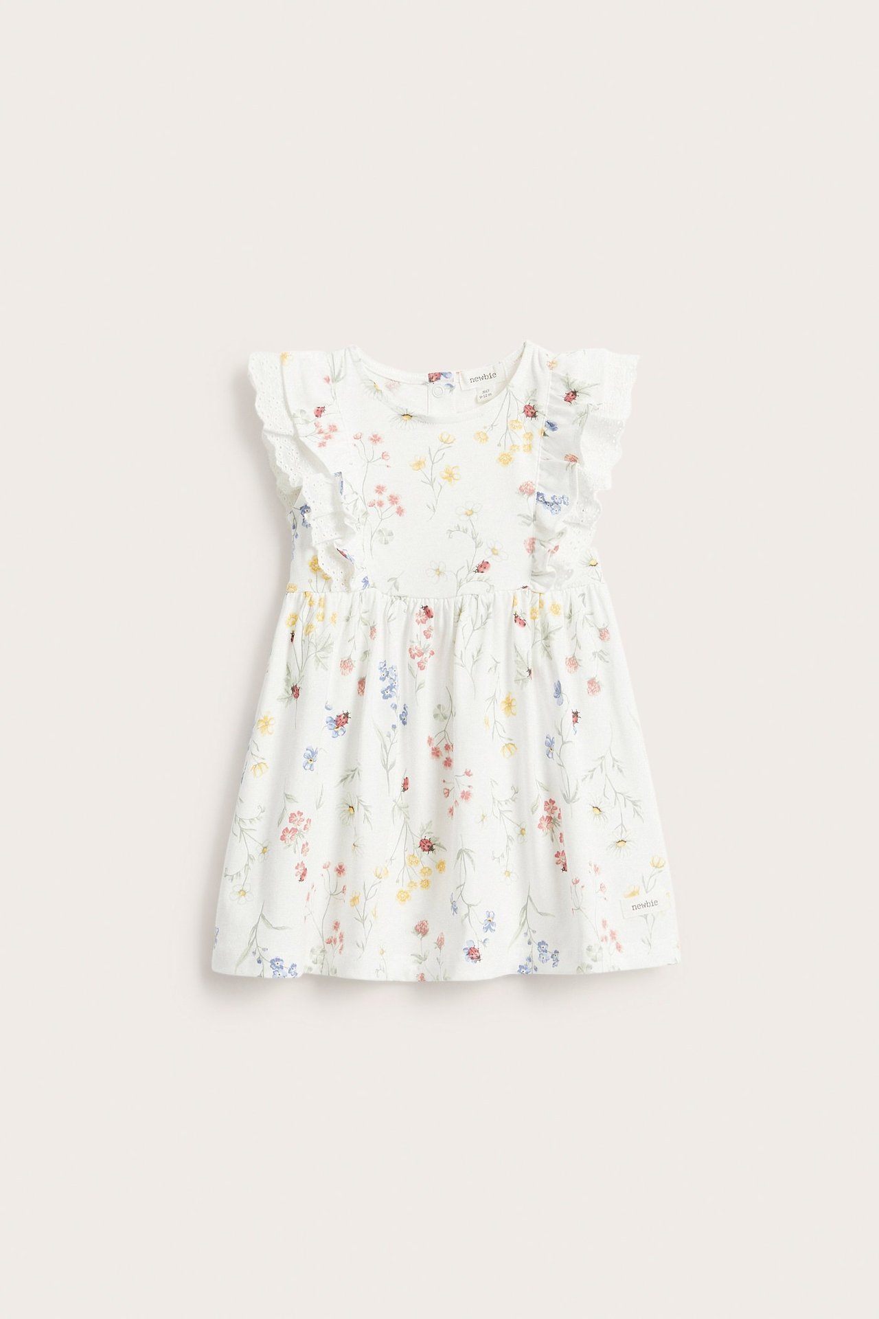 Vorderansicht eines off-white Kinder-Jerseykleides mit Rüschenärmeln, Spitzendetetails und buntem Blumenmuster.