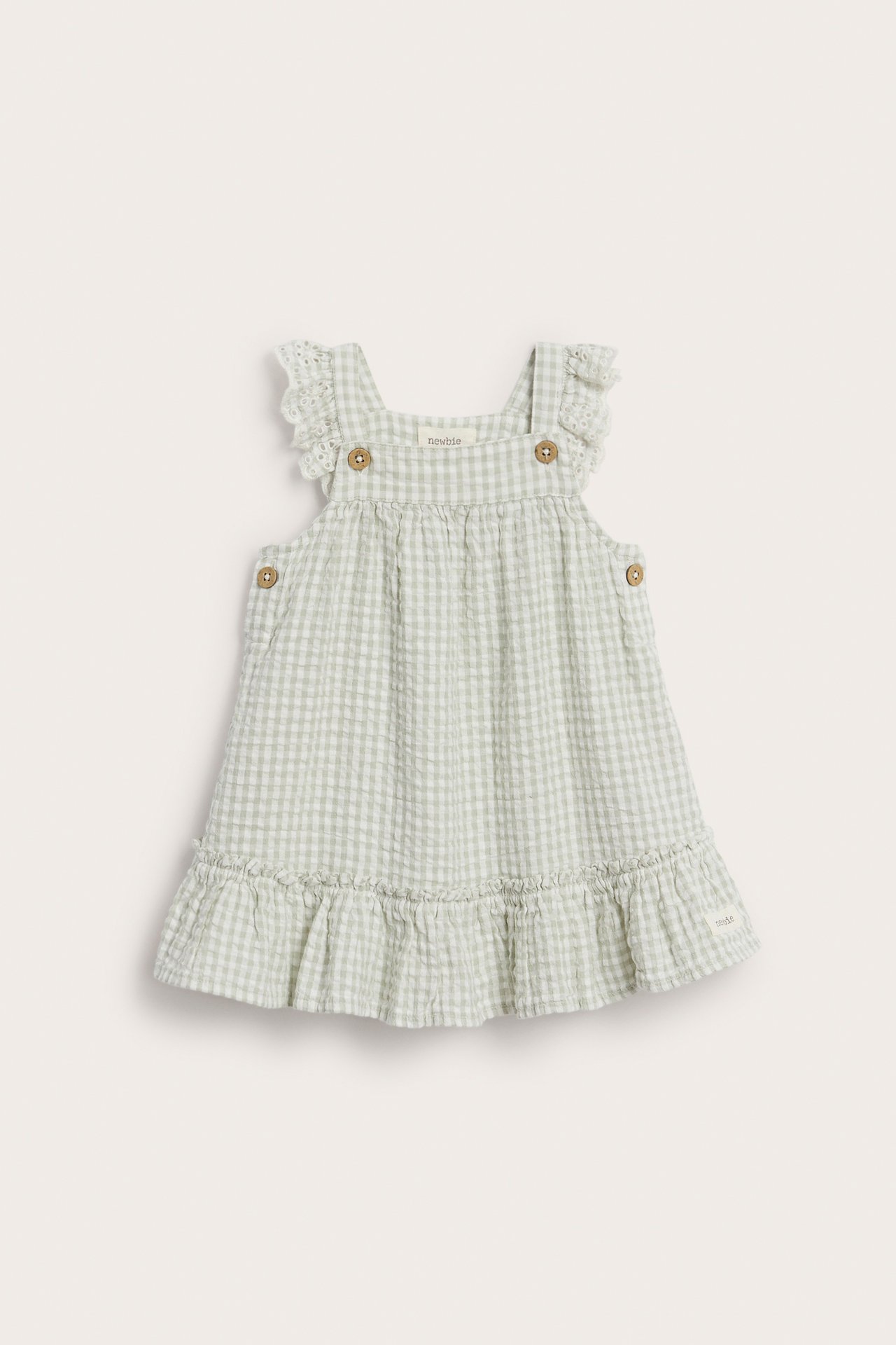 Vorderansicht: Hellgrünes kariertes Babykleid aus Webstoff mit Rüschen und Holzknöpfen.