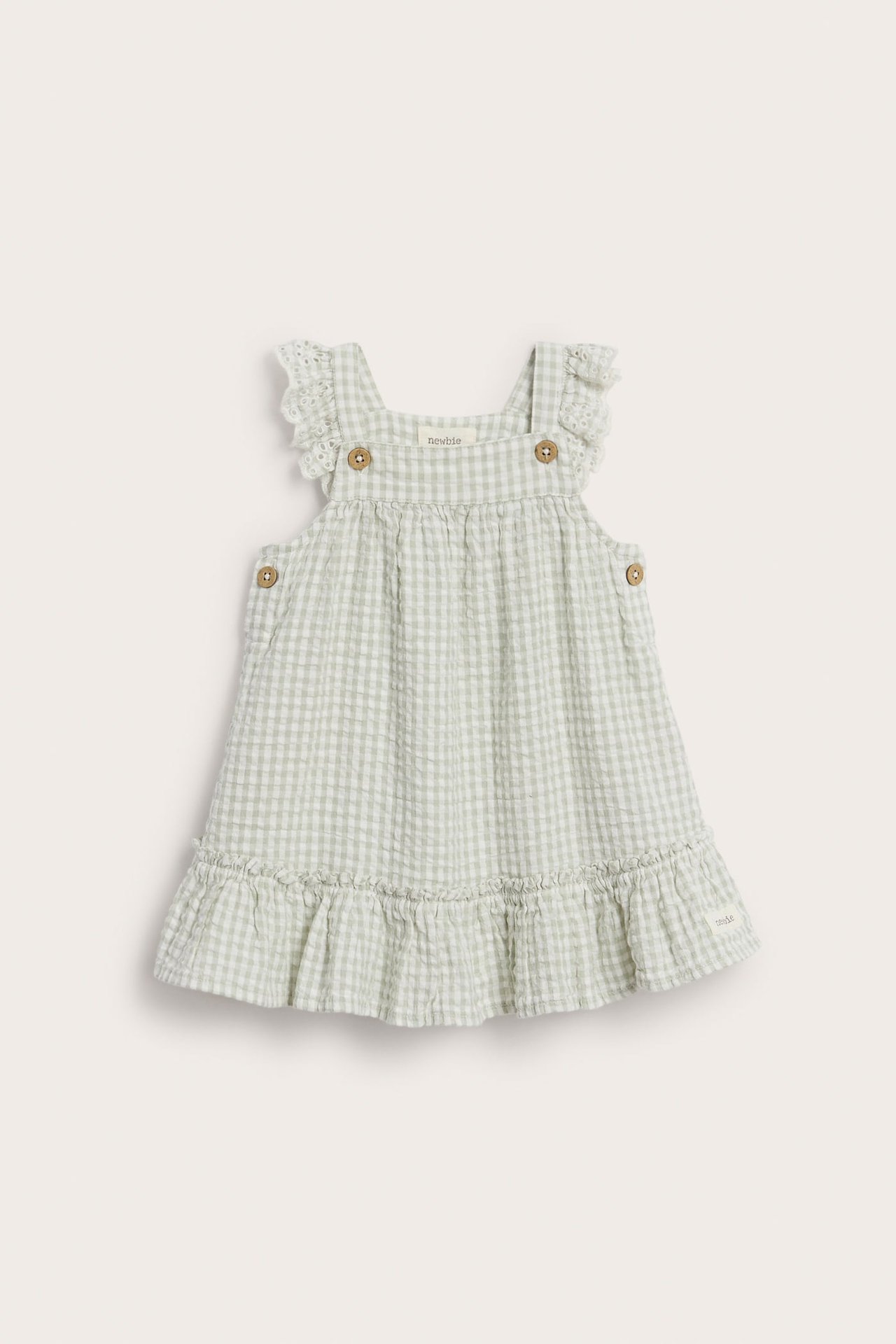 Vorderansicht: Hellgrünes kariertes Babykleid aus Webstoff mit Rüschen und Holzknöpfen.