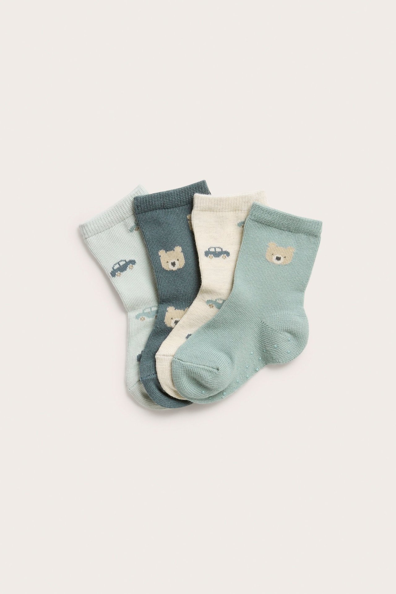 Vier gemusterte Babysocken: beige, hellblau, mintgrün, dunkelpetrol, mit Auto- und Bärenmotiven.