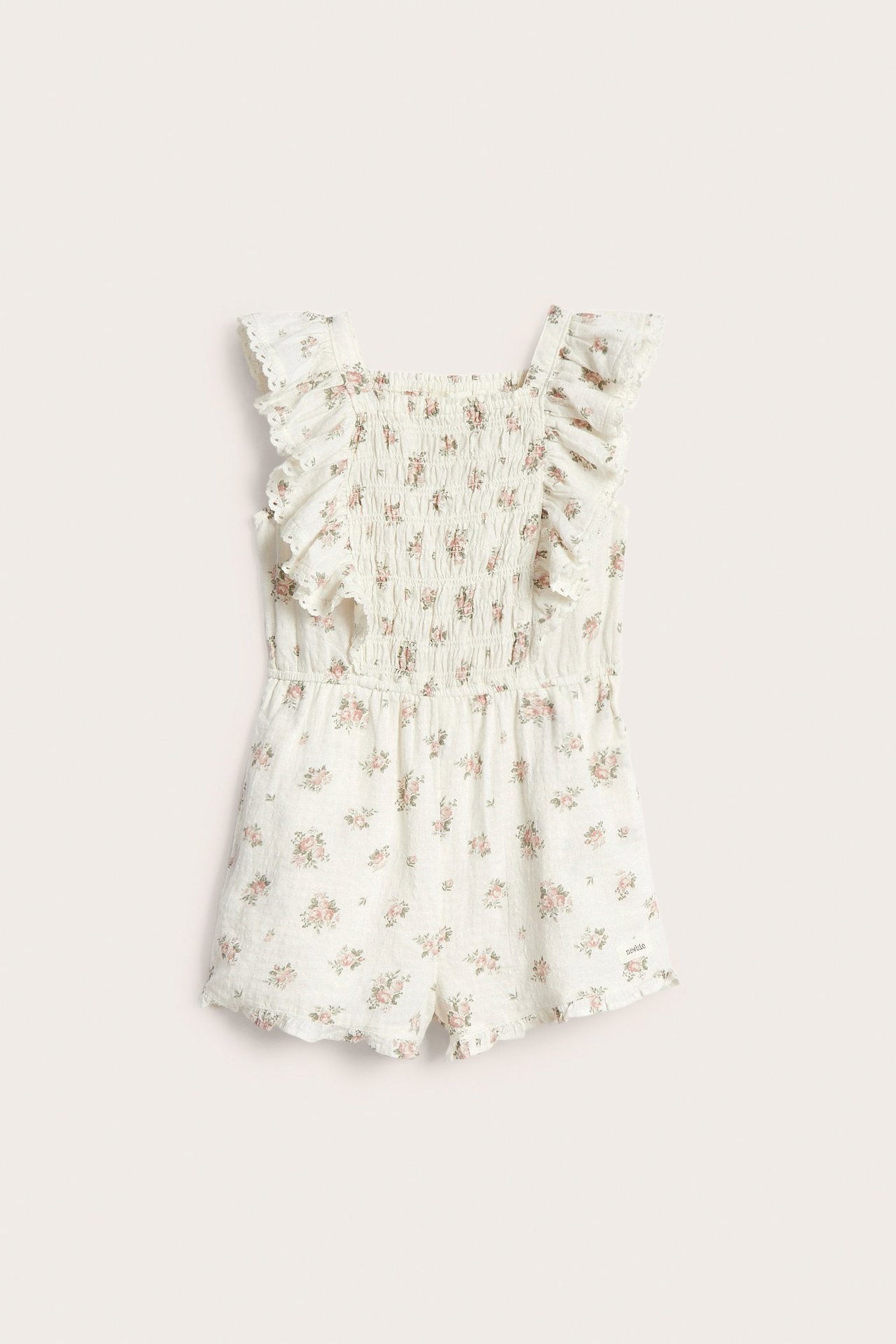 Front view of an off-white floral short jumpsuit with a smocked bodice and ruffled shoulder straps.