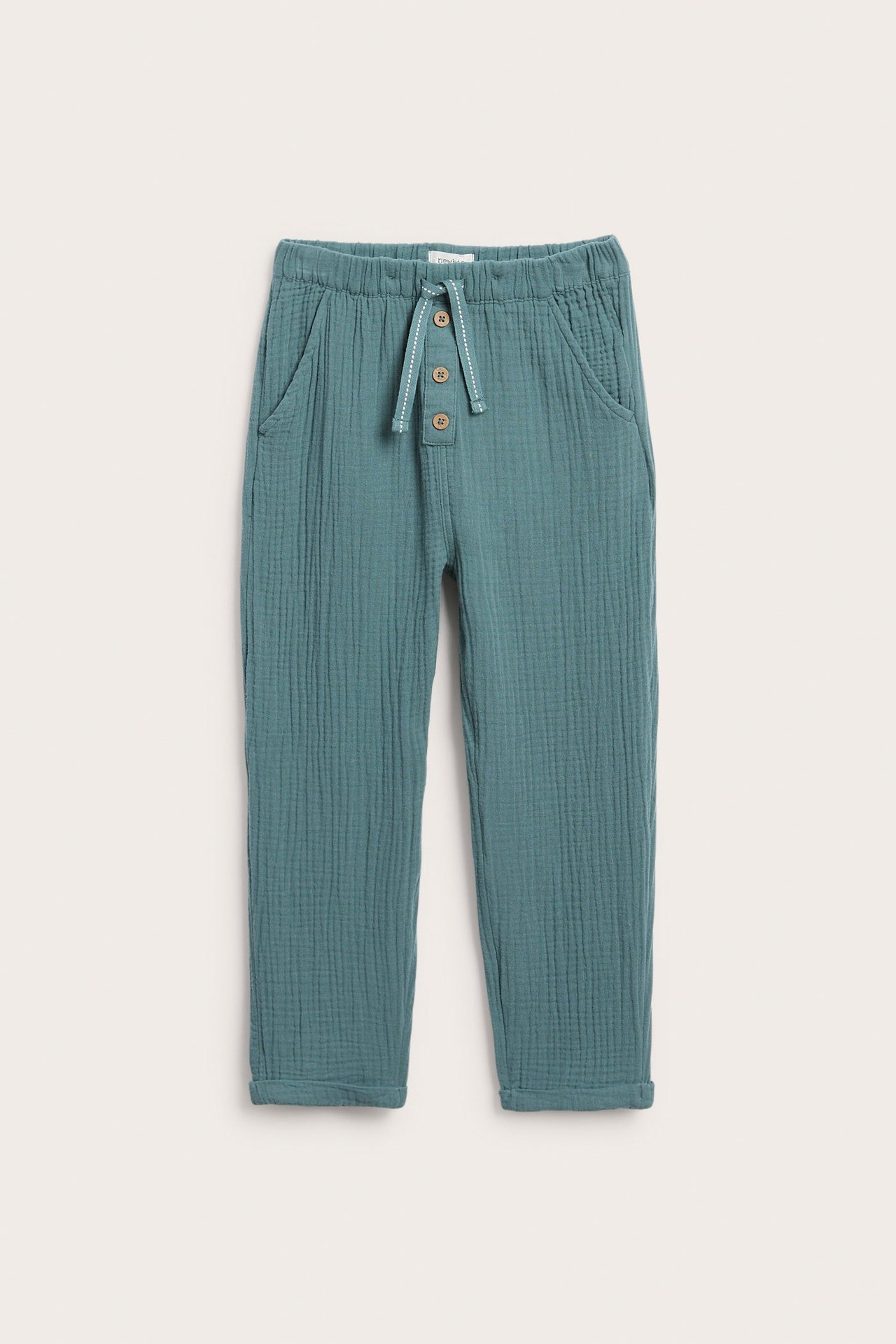 Vorderansicht: Kinder-Hose aus dunkeltürkisem Baumwollmusselin mit Gummibund, Zierkordelzug, Frontknöpfen und aufgerollten Beinabschlüssen.