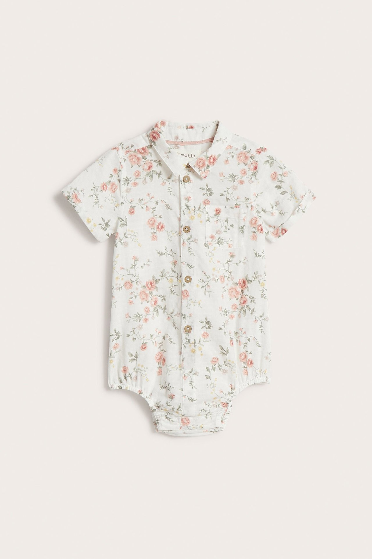 Vorderansicht: Offwhite Baby-Baumwoll-Hemdbody mit rosa Blumenmuster, kurzen Ärmeln und Knöpfen vorne.