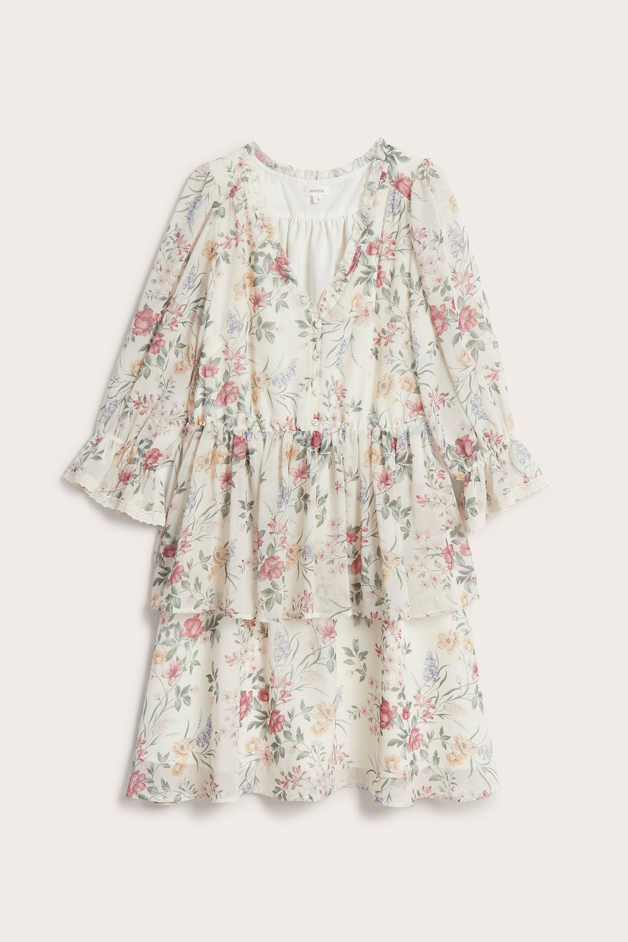 Vorderansicht eines cremefarbenen geblümten Chiffonkleides mit Rüschen, bezogenen Knöpfen und halblangen Elastikärmeln.