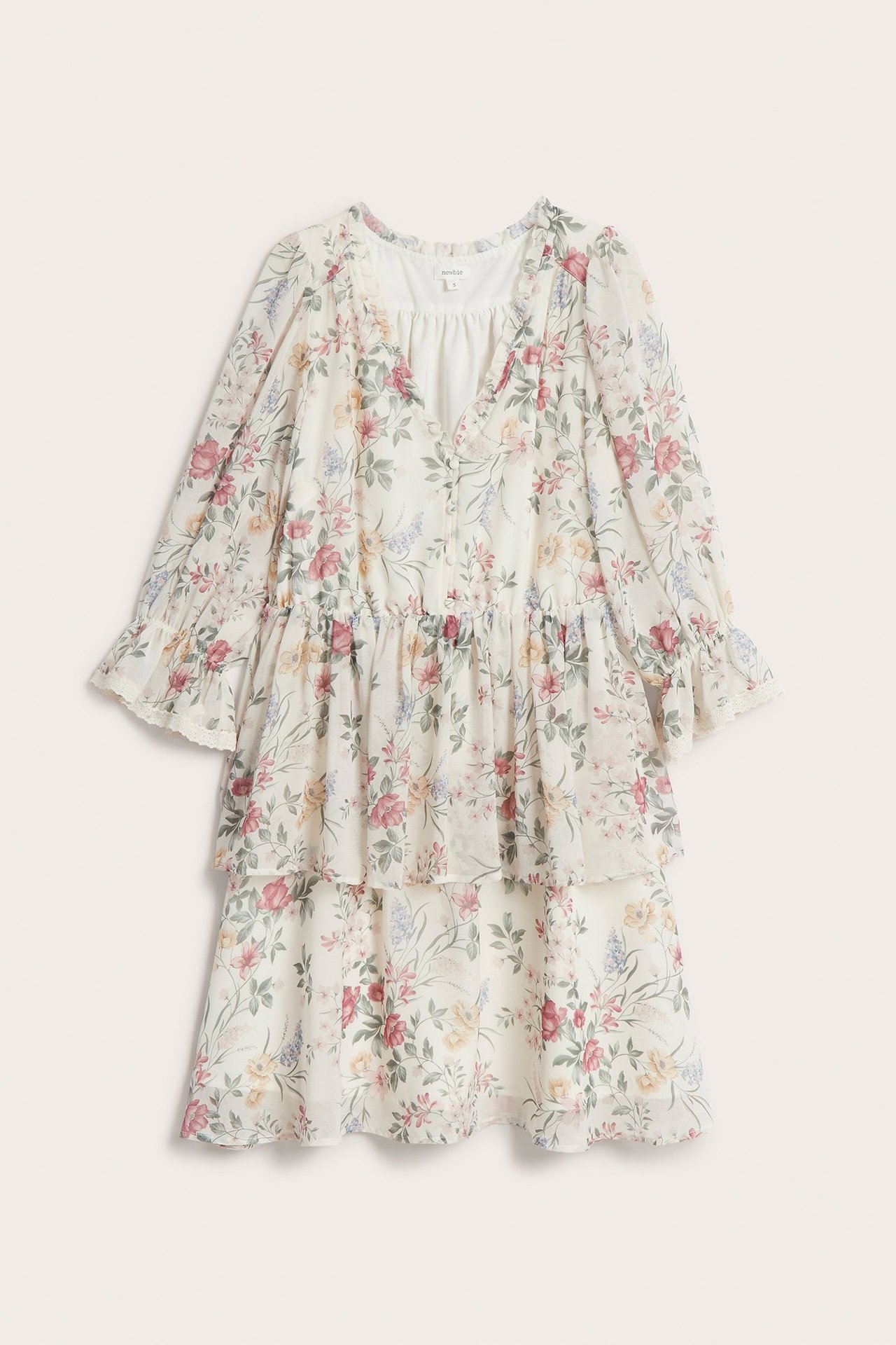 Vorderansicht eines cremefarbenen geblümten Chiffonkleides mit Rüschen, bezogenen Knöpfen und halblangen Elastikärmeln.