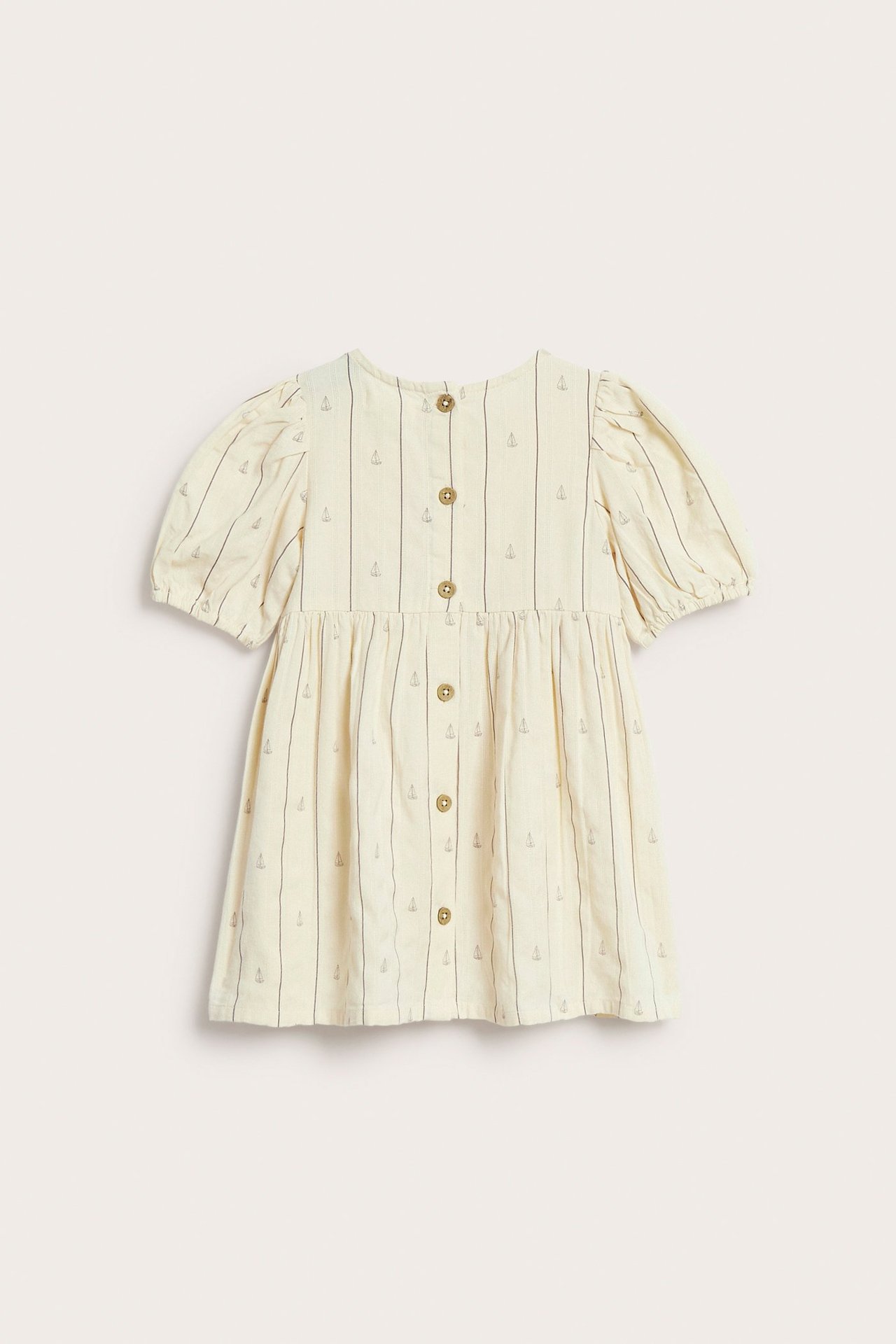 Front view of a kid's off-white cotton dress with vertical stripes and small boat prints, featuring puff sleeves.