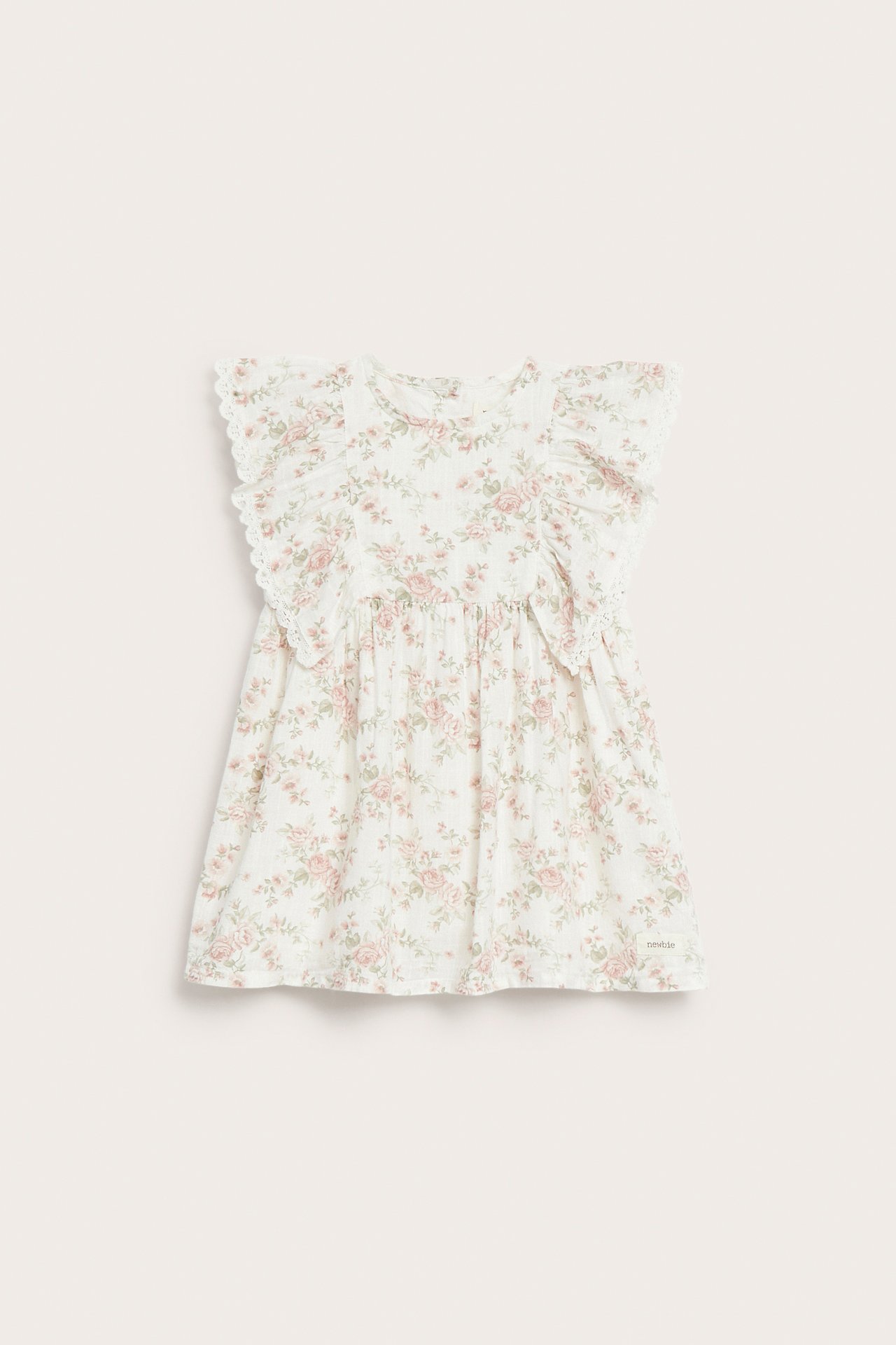 Front view of an off-white baby's dress with pink floral print, ruffles, and lace trim.