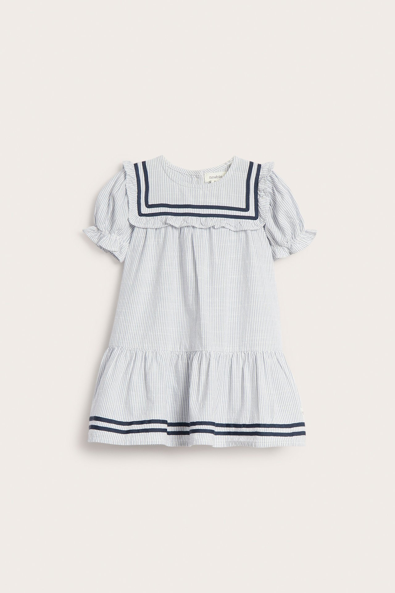 Front view of a kid's blue and white striped cotton dress with a sailor collar, puff sleeves, and ruffles.