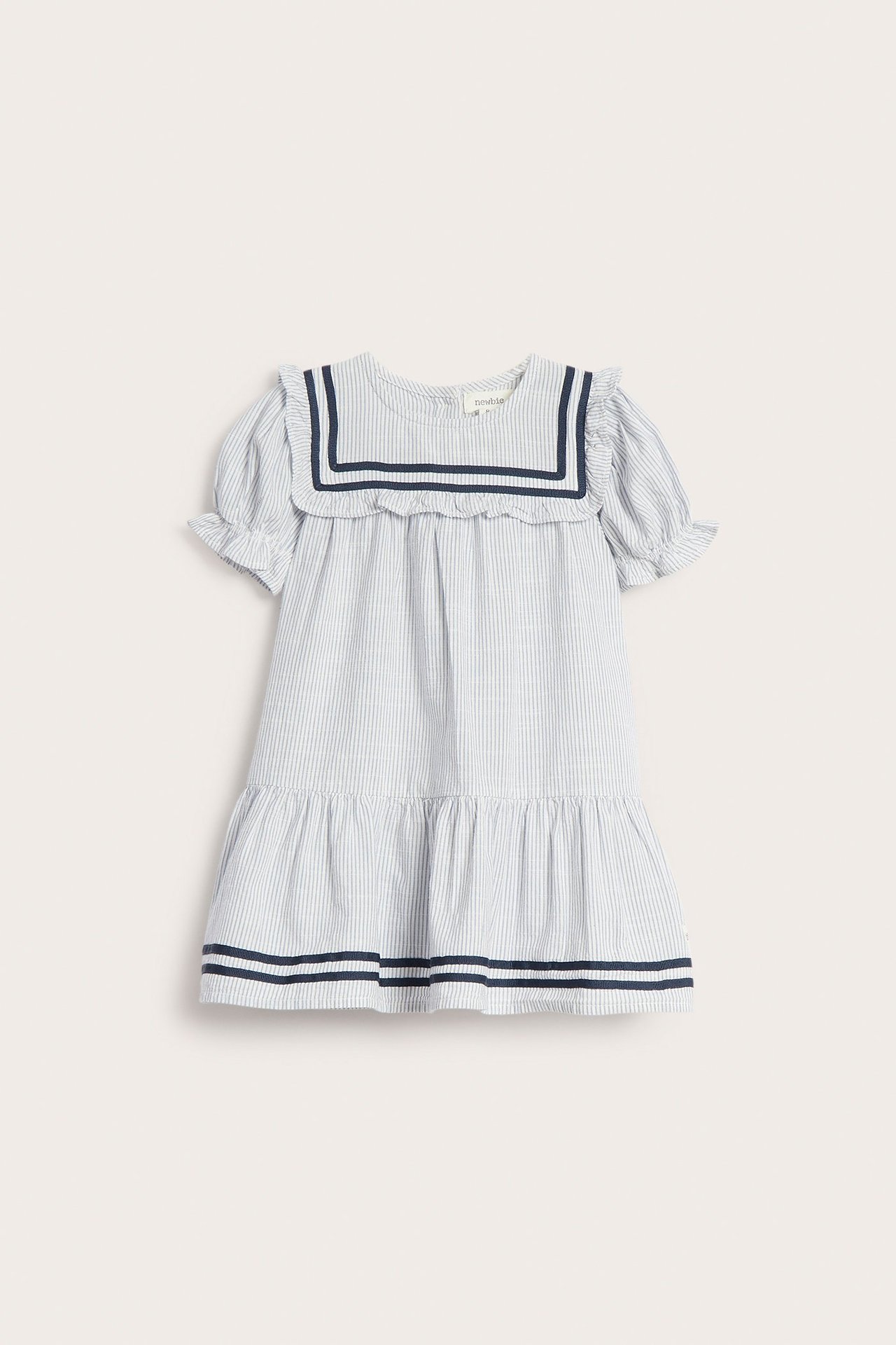 Front view of a kid's blue and white striped cotton dress with a sailor collar, puff sleeves, and ruffles.