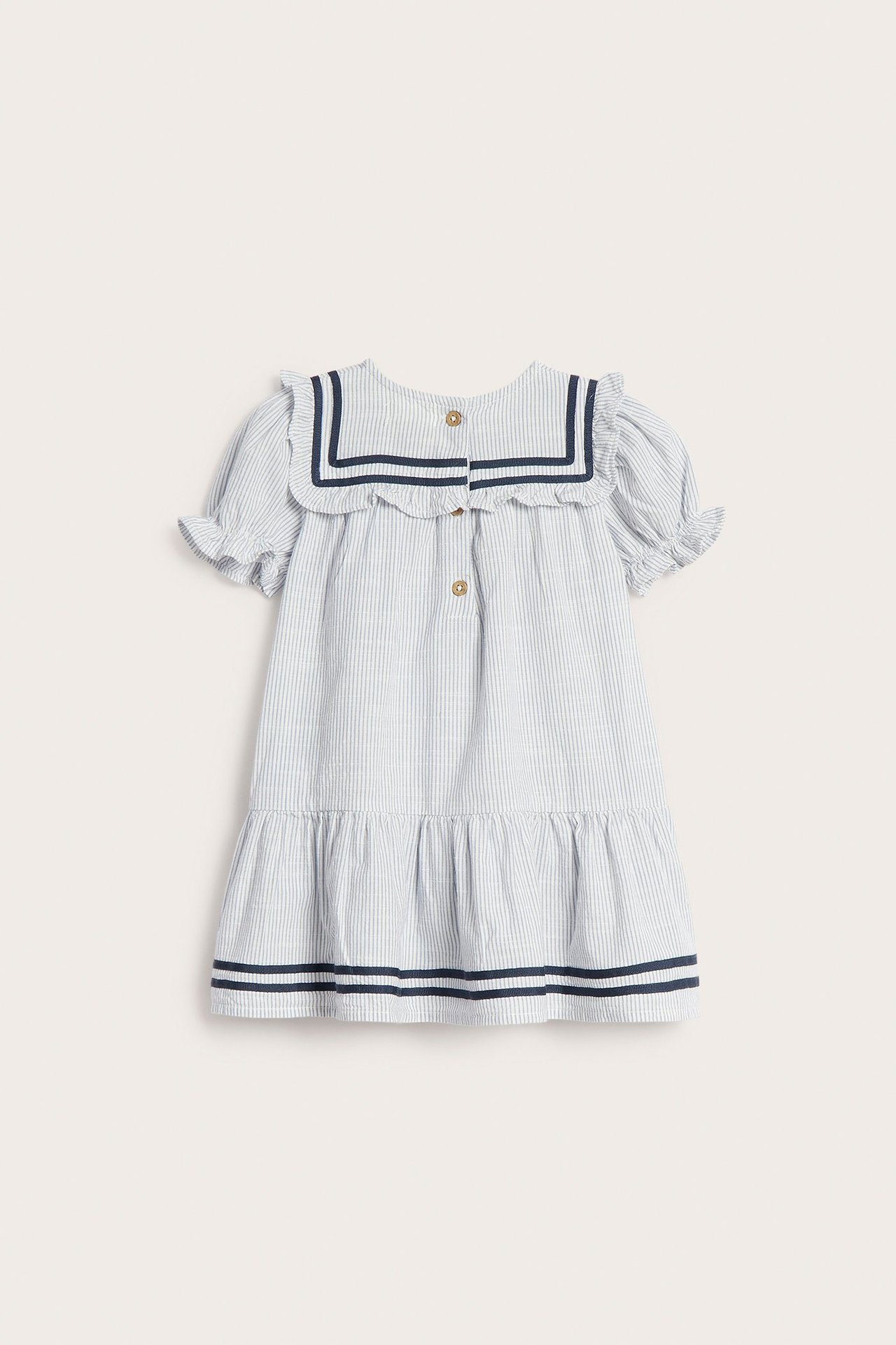 Back view of a kid's blue striped cotton dress with a sailor collar, puff sleeves, and back buttons.