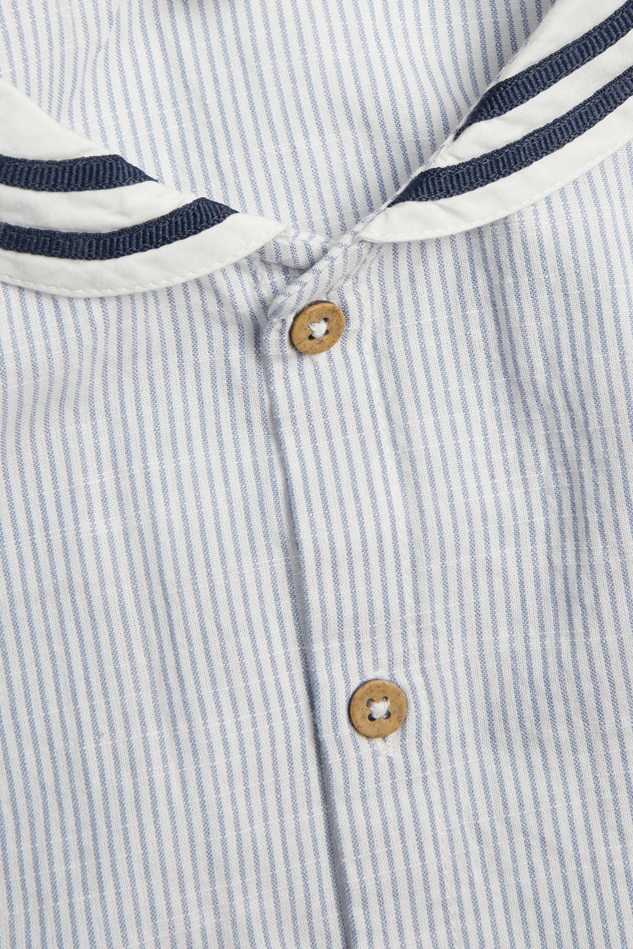 Close-up front view of a blue and white striped woven cotton shirt with a sailor collar and wooden buttons.