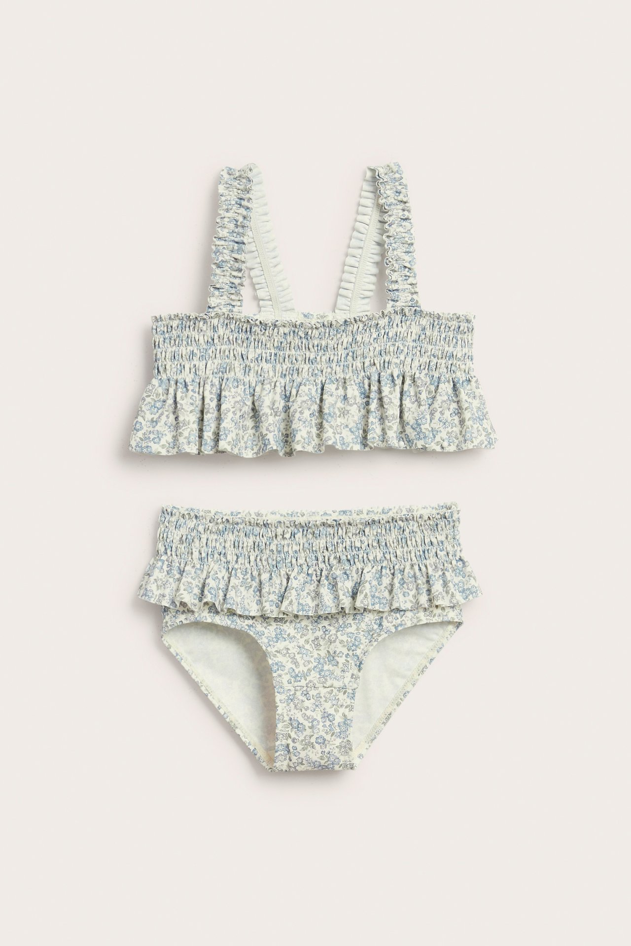 Front view: kid's bikini with smocked top and bottom in light blue/green floral print, ruffled straps.