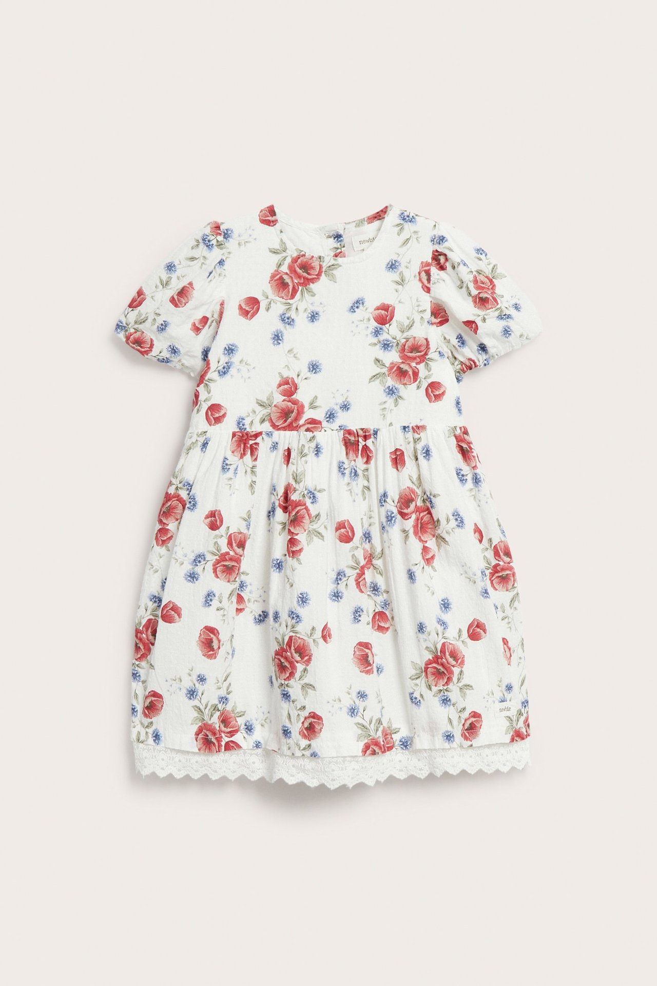 Front view: Off-white woven kid's dress with red and blue floral pattern, balloon sleeves, and lace hem.