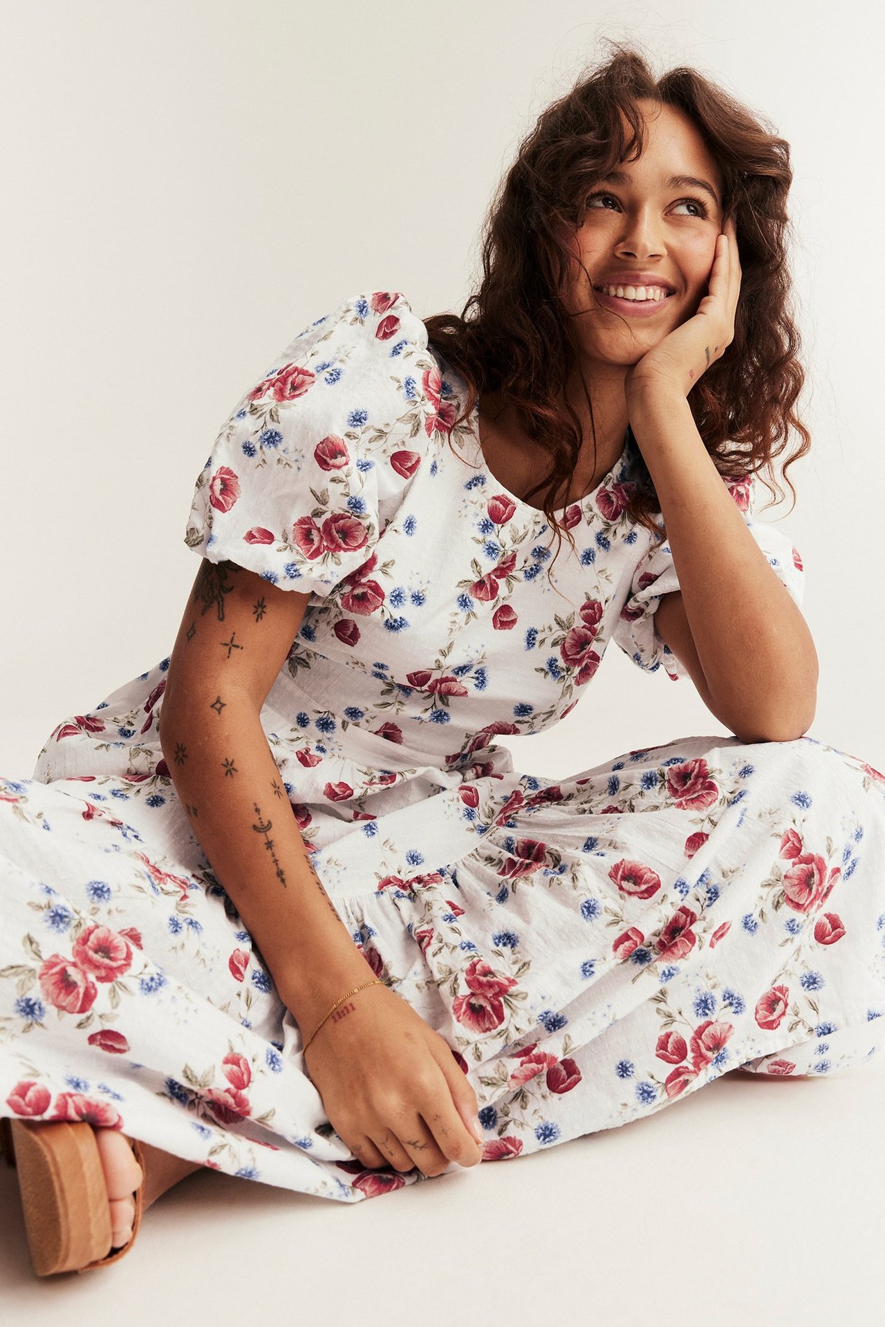 Front view: Woman wears an off-white floral woven dress with balloon sleeves and brown platform sandals.