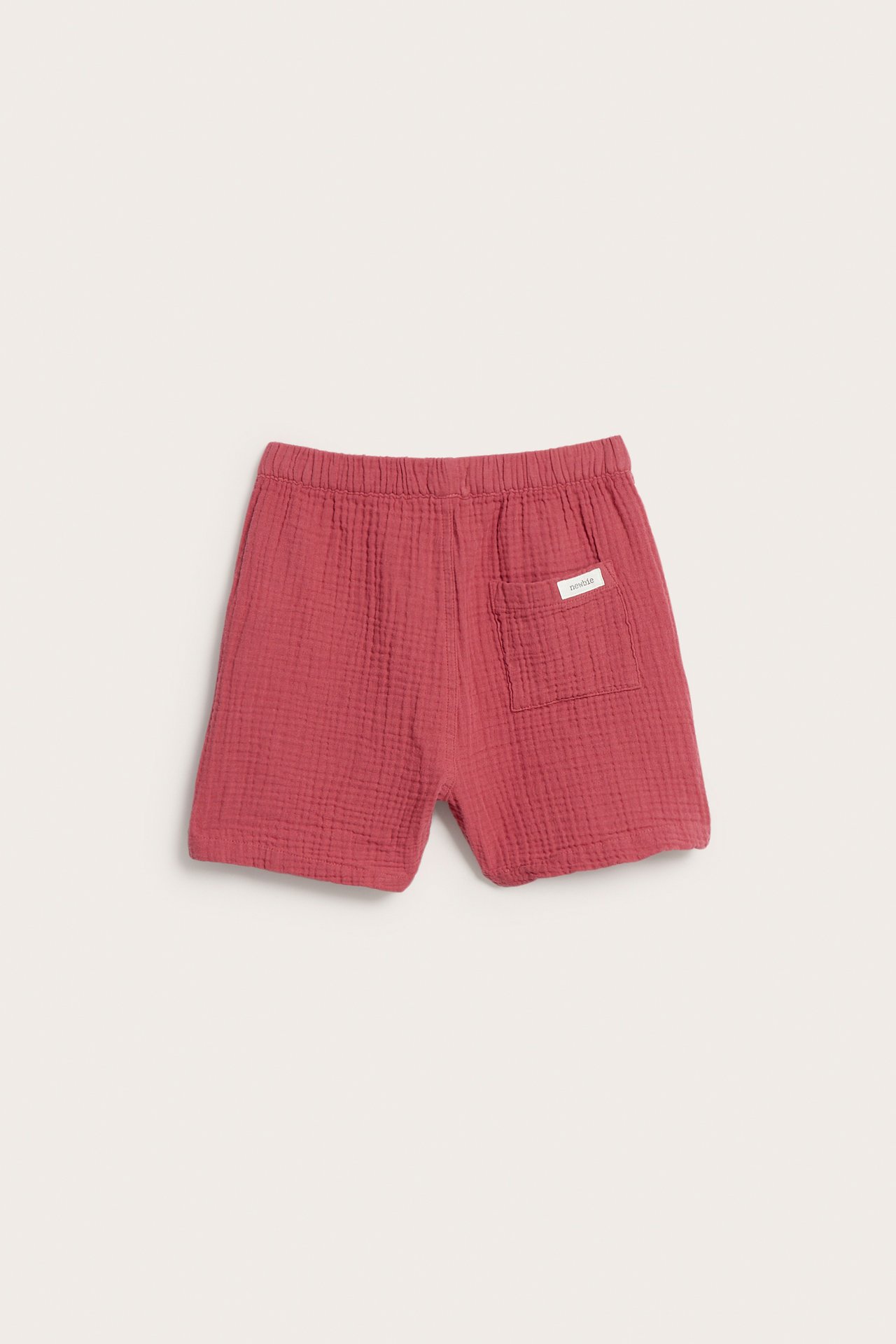 Rote, einfarbige gewebte Baumwollshorts mit elastischem Bund und aufgesetzter Gesäßtasche, Rückansicht.