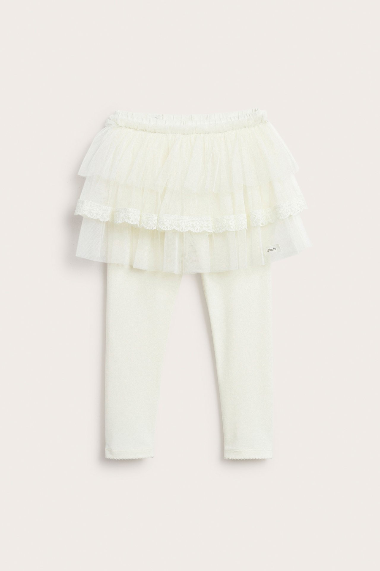 Front view of offwhite kid's leggings with an attached three-tiered tulle skirt, featuring a lace trim.