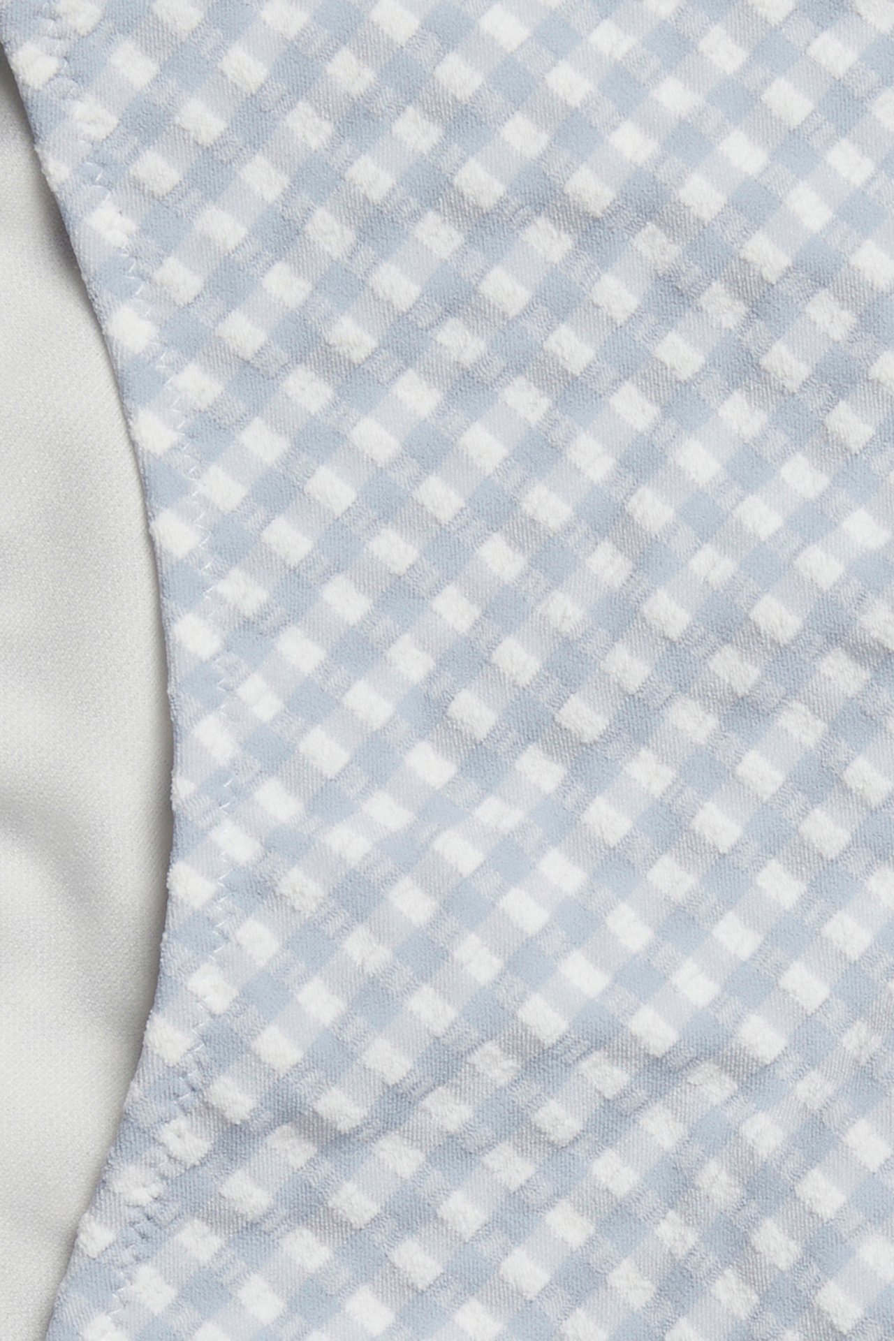 Close-up of a blue and white checked high-waisted bikini bottom with a textured fabric.