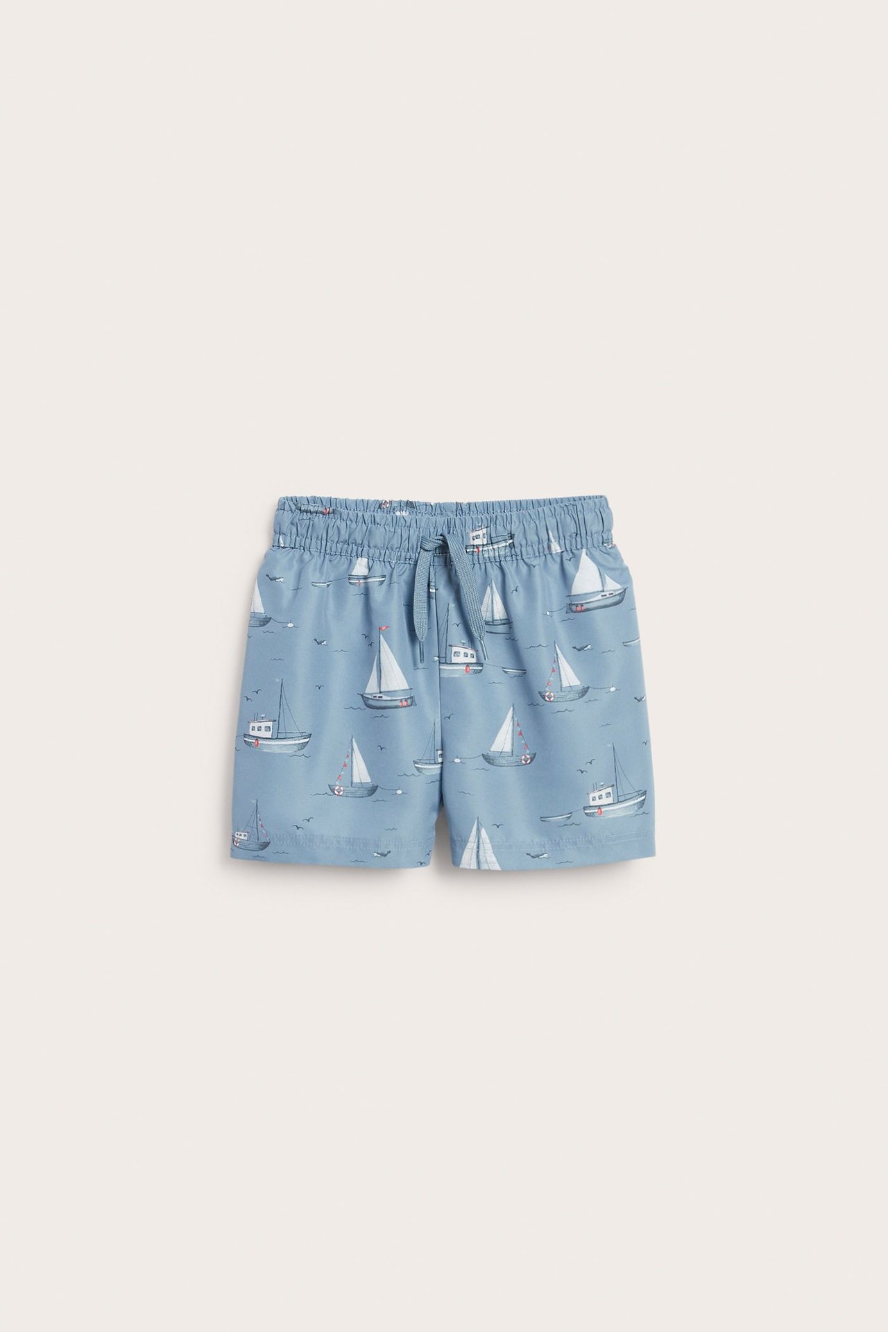 Vorderansicht blauer Kinder-Badeshorts mit Bootmuster und Kordelzug am Bund.