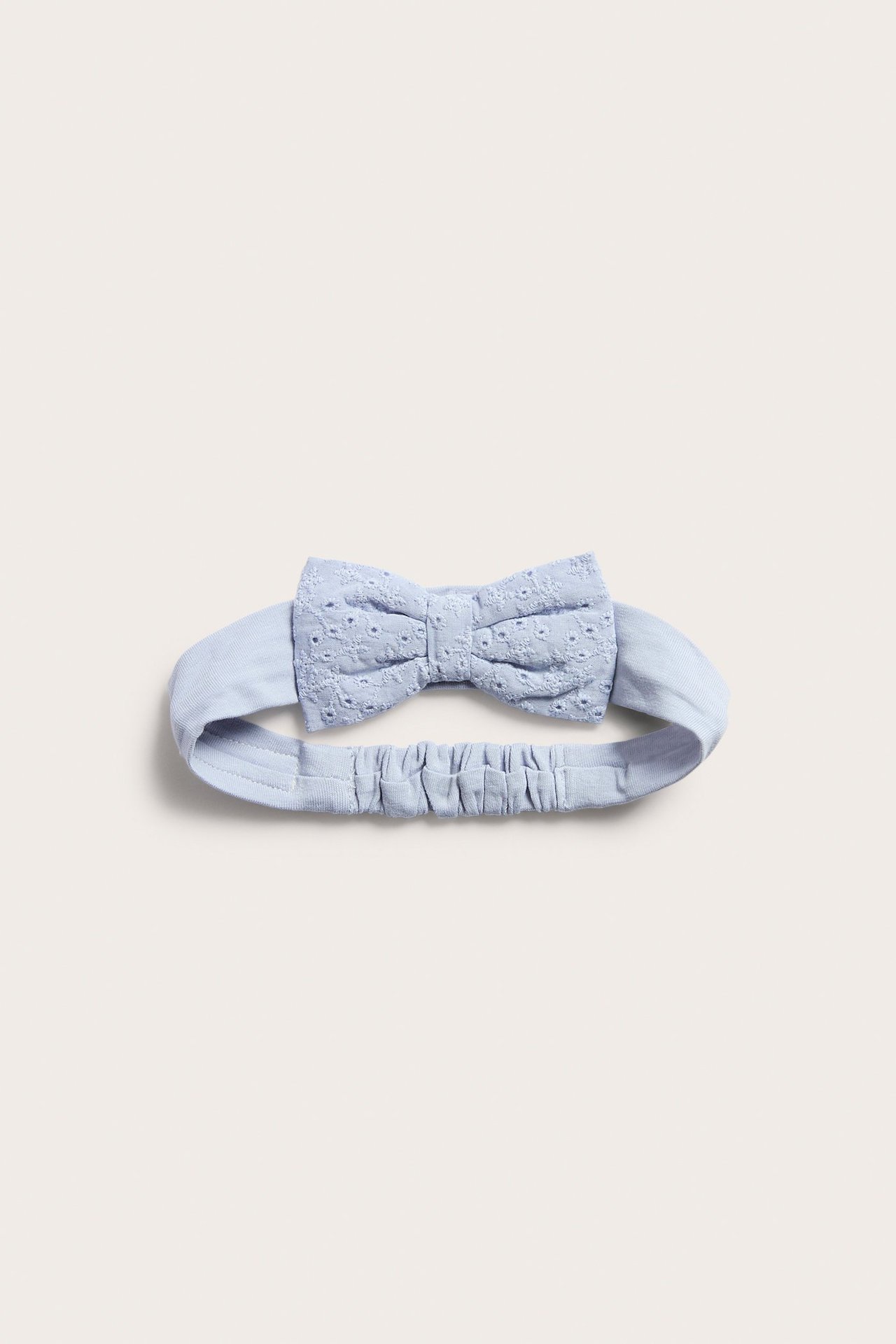 Vorderansicht eines hellblauen Baby-Jersey-Haarbands mit Gummizug und einer zarten Spitzen-Schleife.
