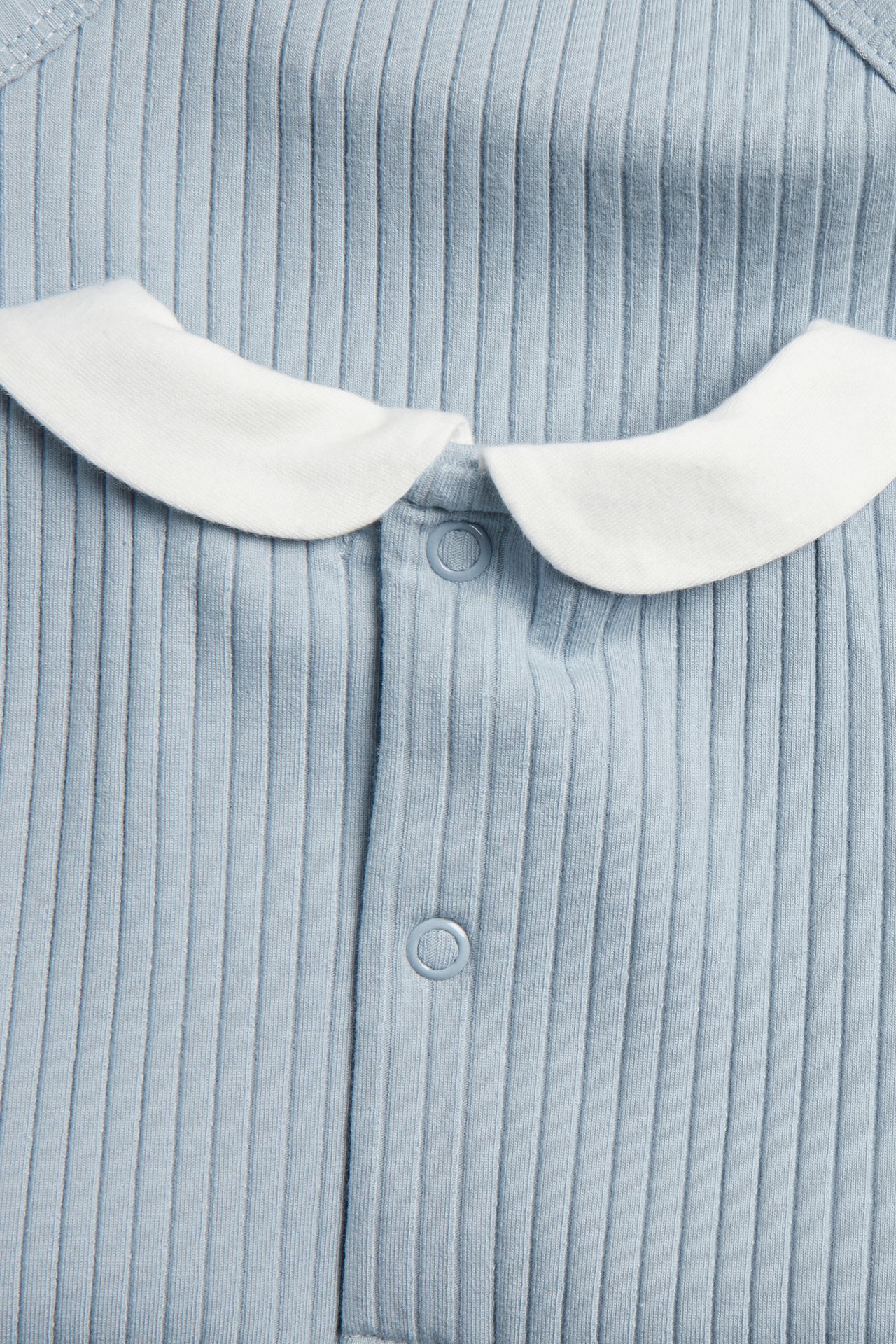 Close-up front view of a baby's blue ribbed bodysuit with a white collar and snap buttons.
