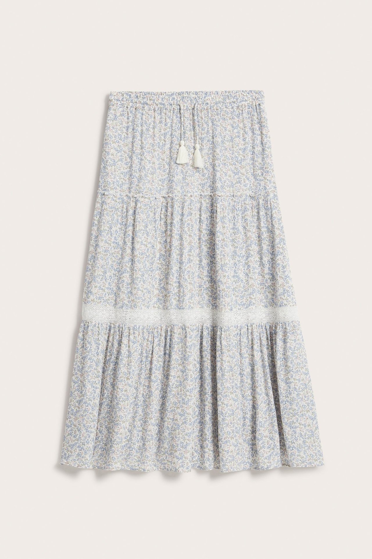 Vorderansicht: Offwhite langer Stufenrock mit Blumenmuster, Spitzendetail, Gummibund und Quasten.