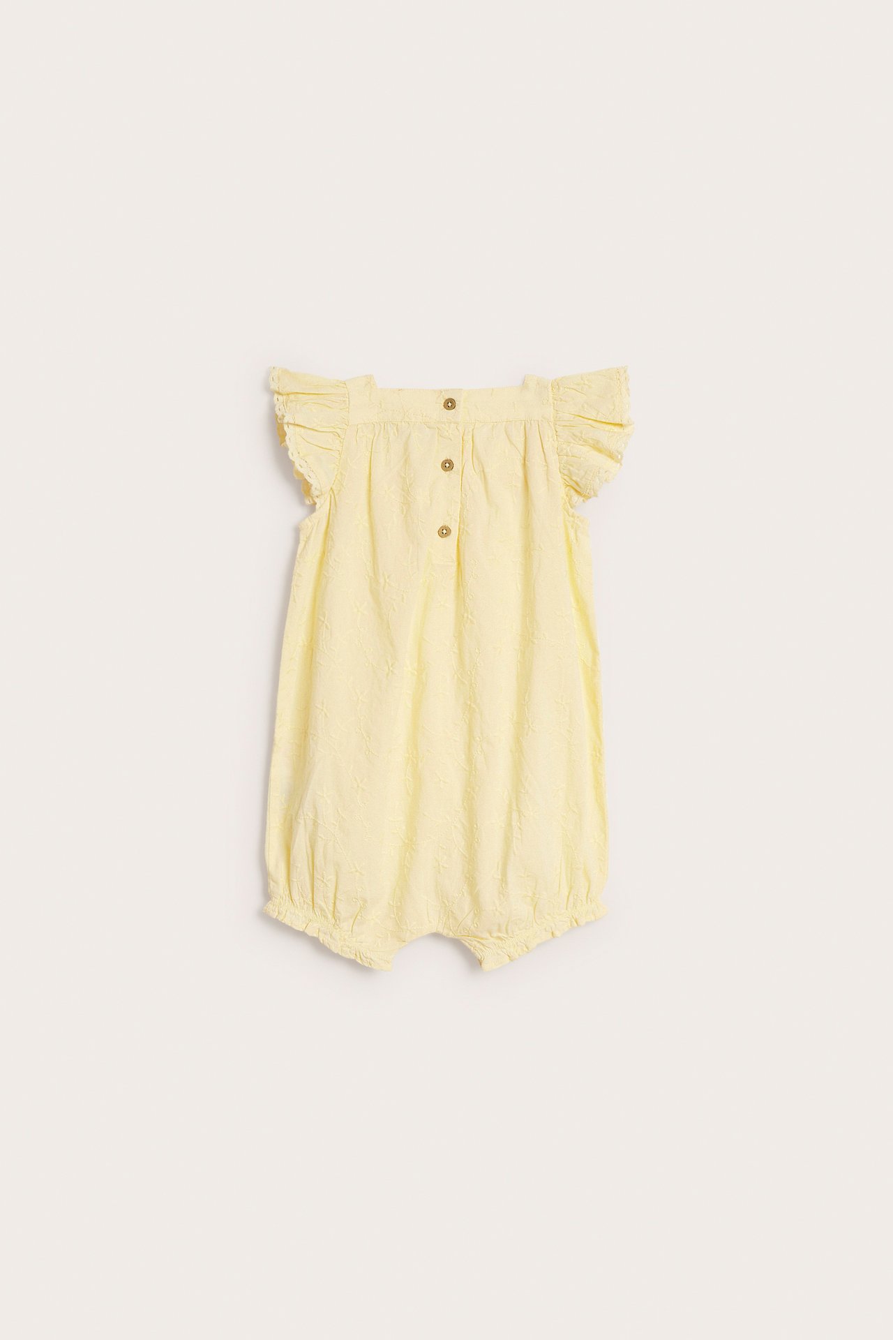 Back view: Baby's yellow woven cotton romper, embroidered, with ruffle sleeves and back buttons.