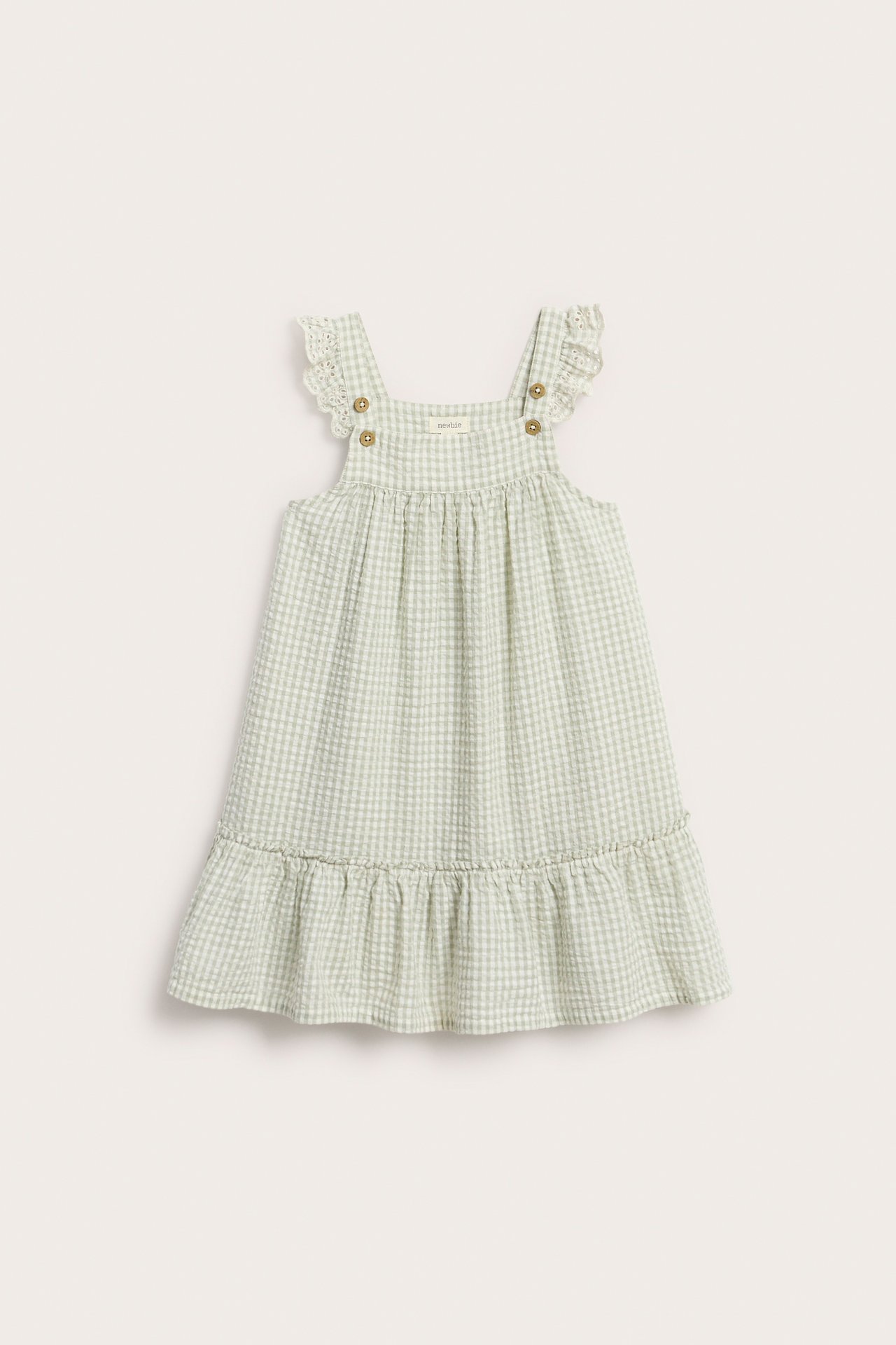 Vorderansicht: Hellgrünes kariertes Kinderkleid mit bestickten Schulterrüschen und Rüschensaum.