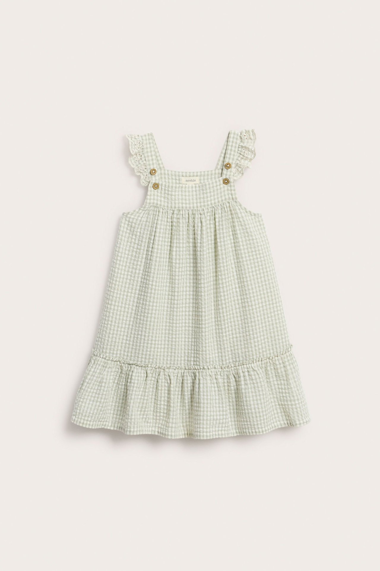 Vorderansicht: Hellgrünes kariertes Kinderkleid mit bestickten Schulterrüschen und Rüschensaum.