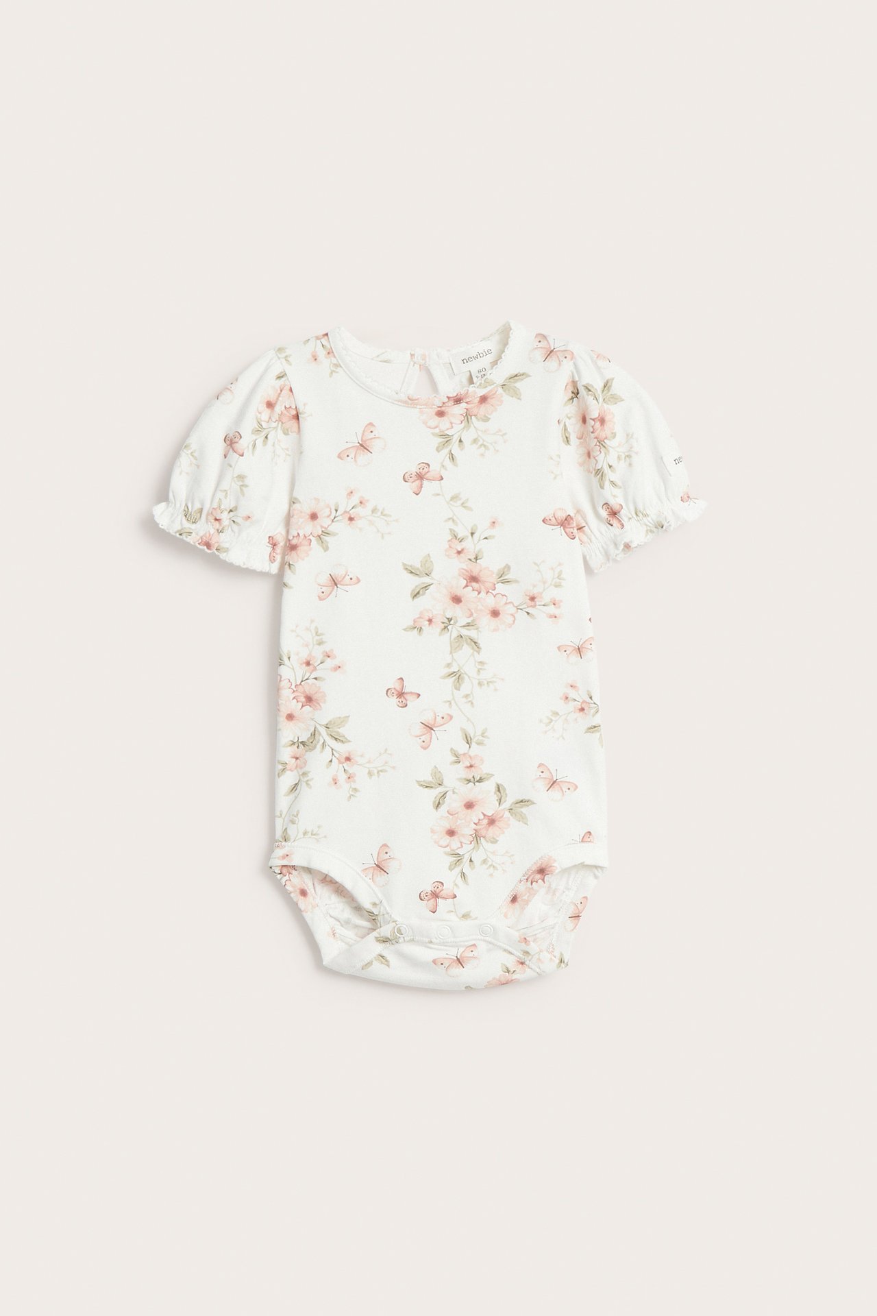 Front view of an offwhite baby bodysuit with a floral and butterfly print, short puff sleeves, and crotch snaps.