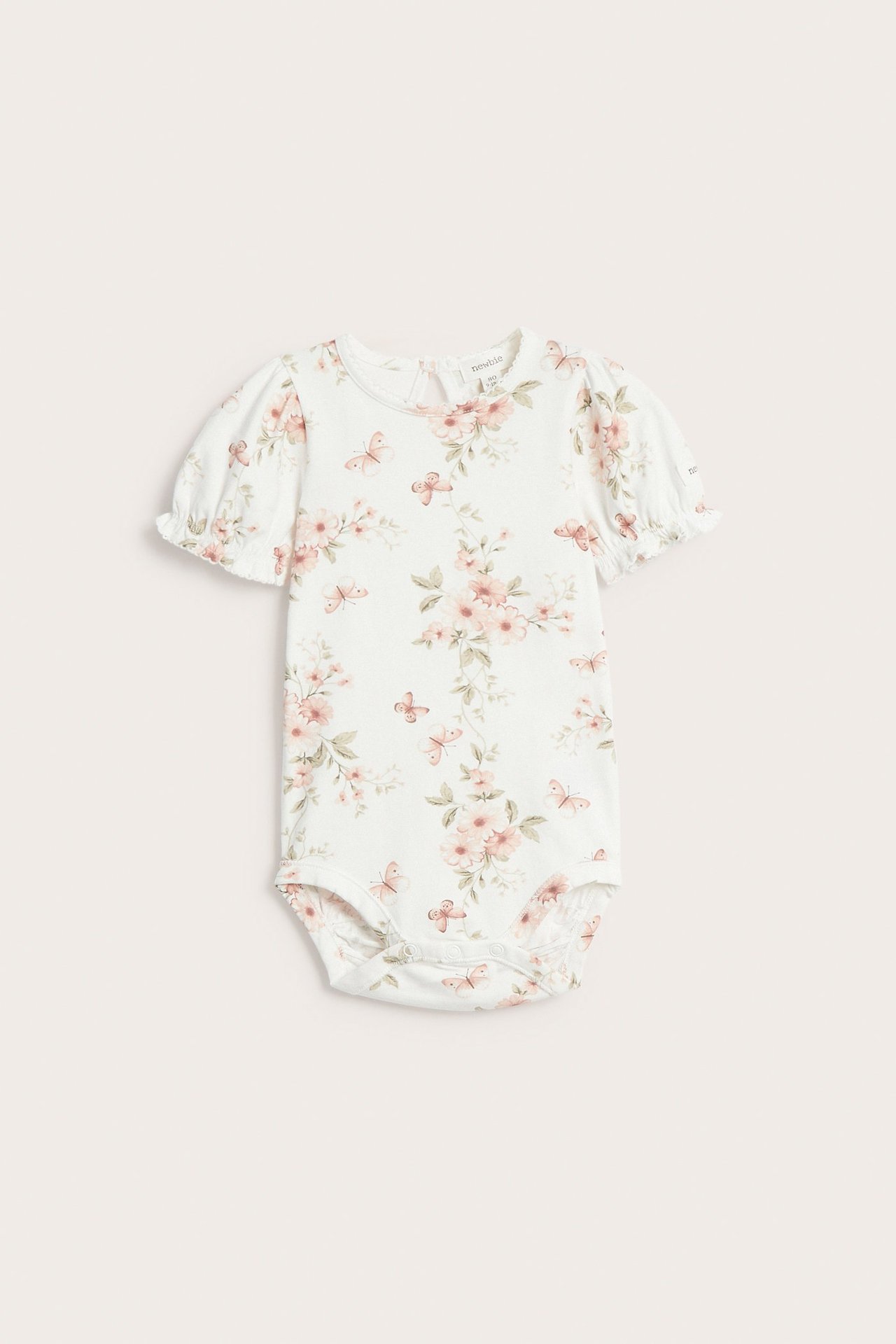 Vorderansicht eines cremeweißen Babybodys mit Blumen- und Schmetterlingsmuster, kurzen Puffärmeln und Druckknöpfen.