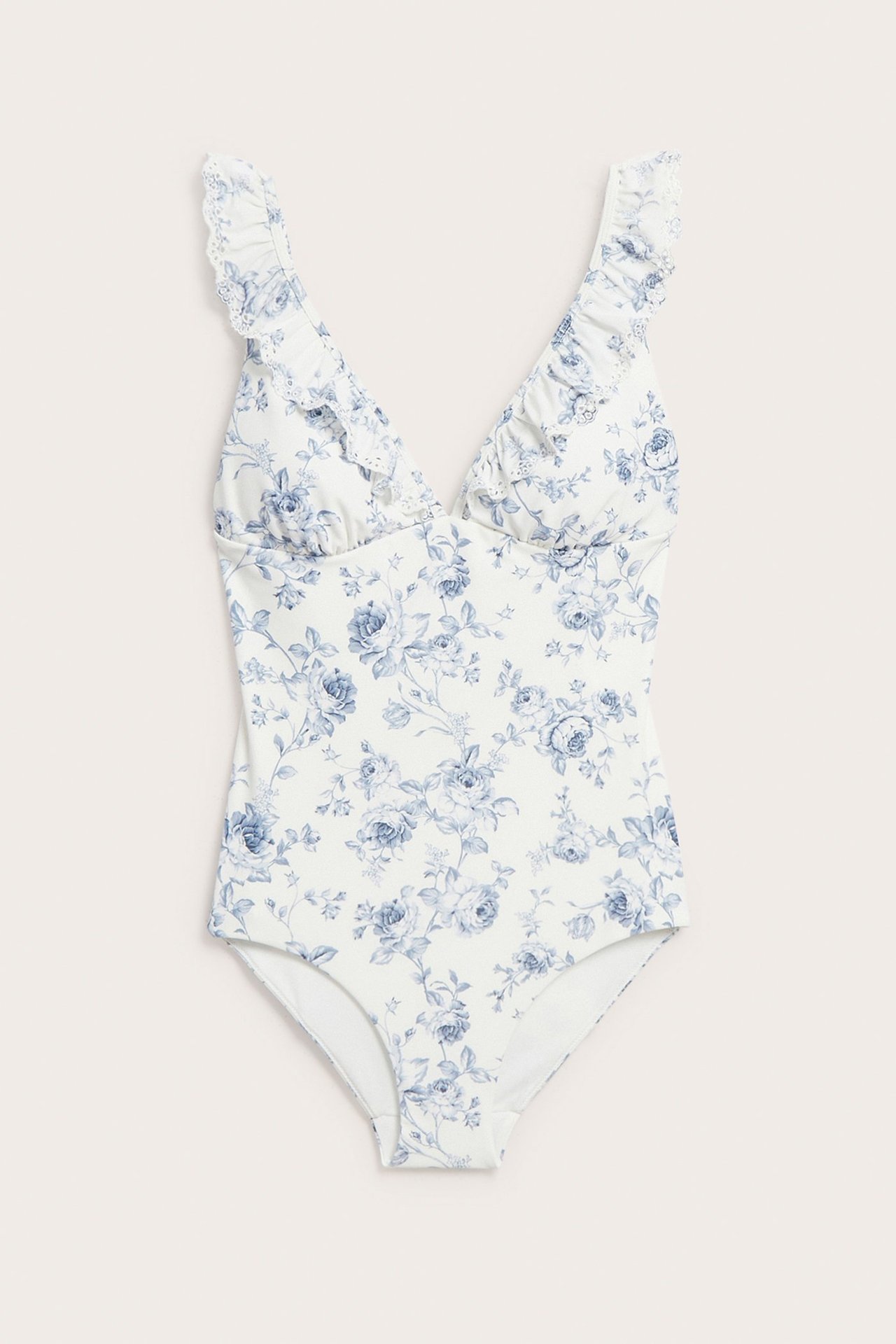 Front view of an off-white floral swimsuit with a V-neck, ruffles, and blue floral pattern.