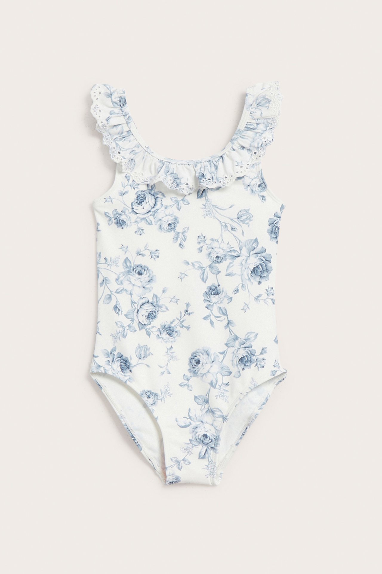 Front view: off-white kid's floral swimsuit with blue roses and ruffled, embroidered straps.