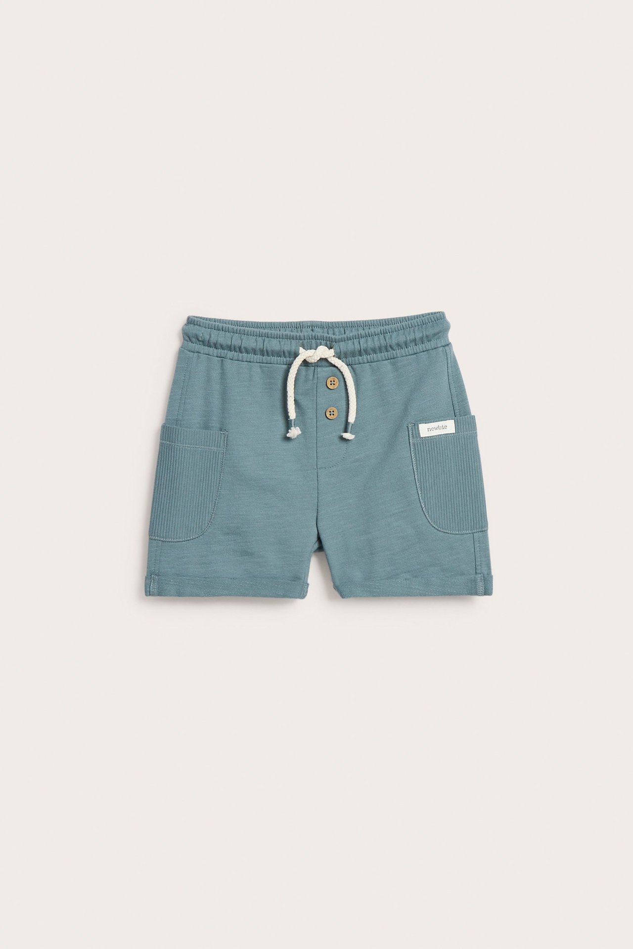 Front view of kid's dark turquoise slub jersey shorts with ribbed side pockets, rolled cuffs, and decorative buttons.