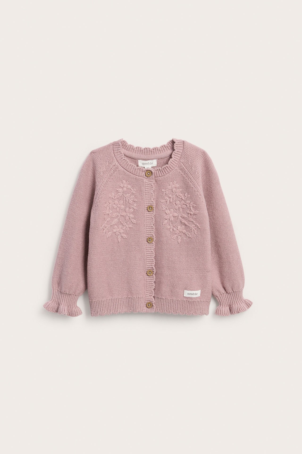 Vorderansicht einer rosa Strickjacke für Babys mit Blumenstickerei und Holzknöpfen.